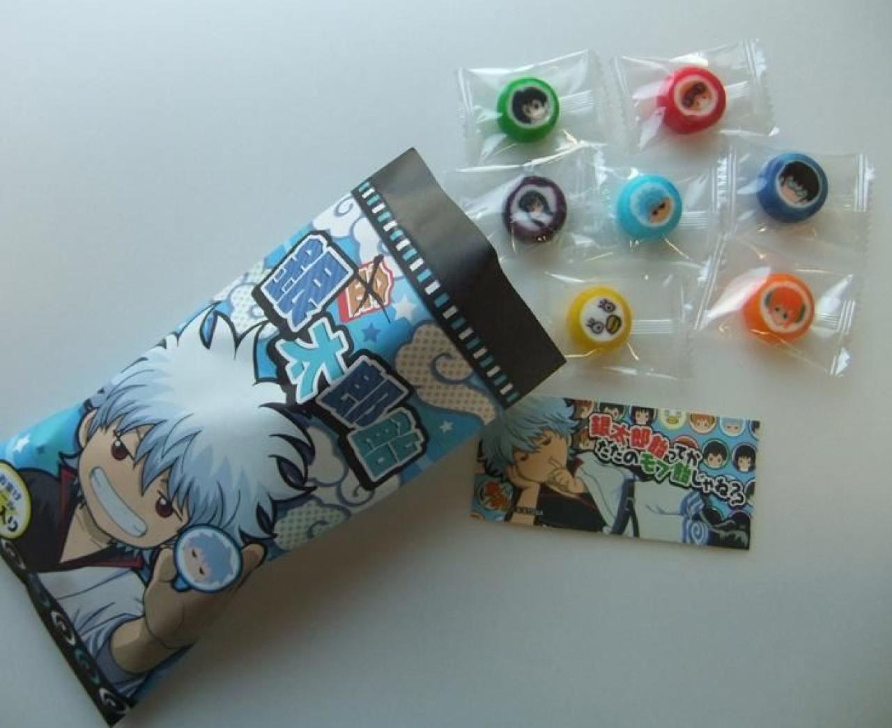 拆开包装的“银太郎饴”，里面七位主角的金太郎饴糖果和附送的卡片