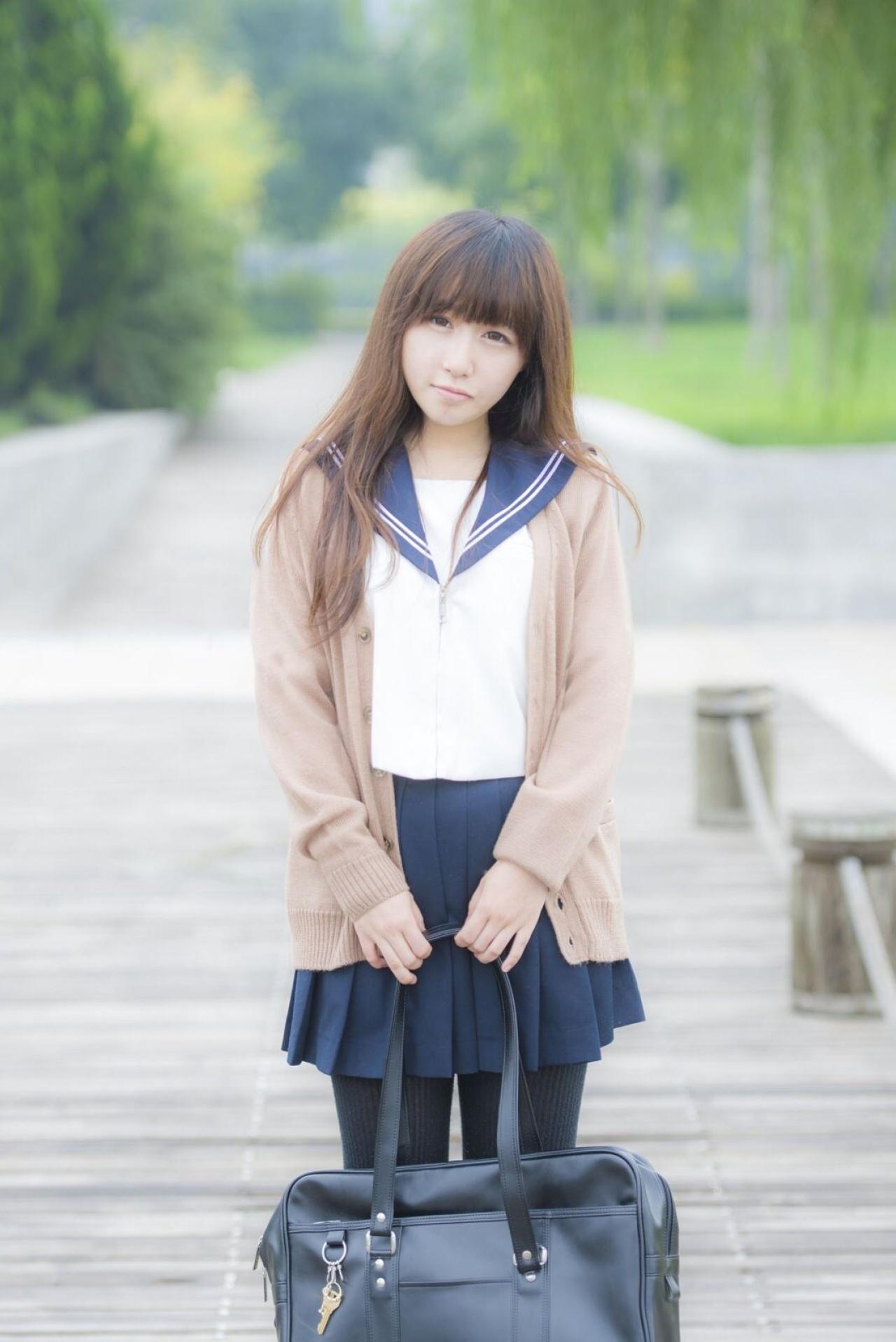 曈曈响叮当双手握着包放在腰间