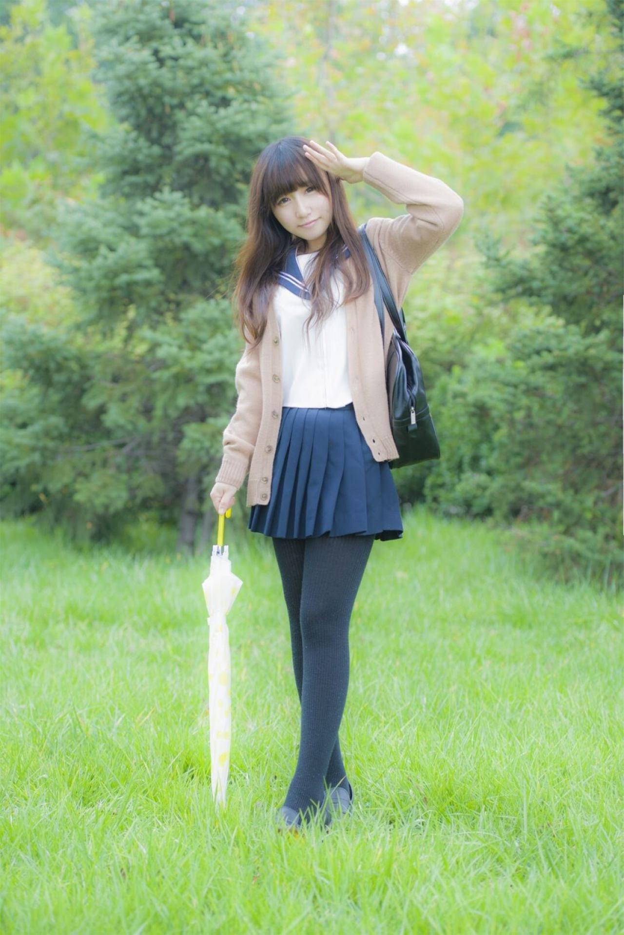 曈曈响叮当右手拿着伞，左手伸展放在刘海儿一侧