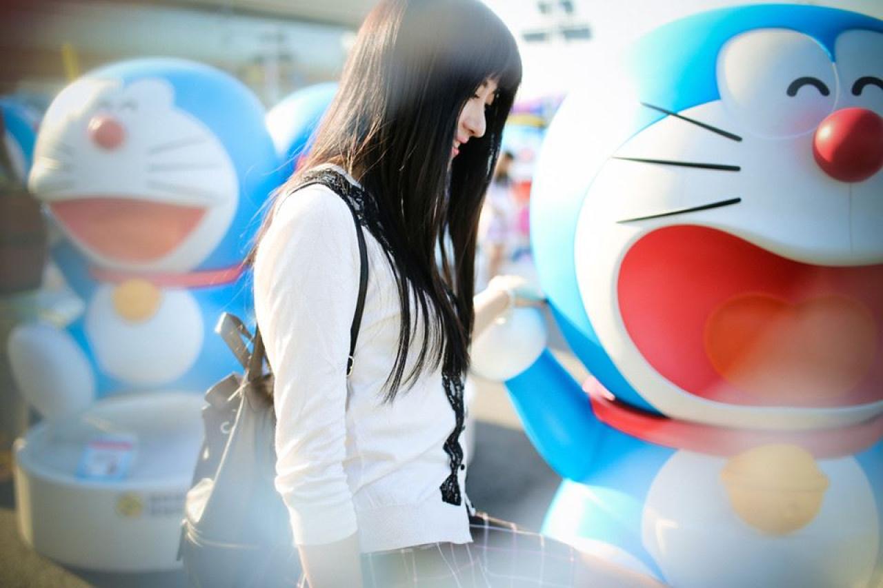 嗡嗡在张大嘴巴笑的哆啦A梦旁的侧脸