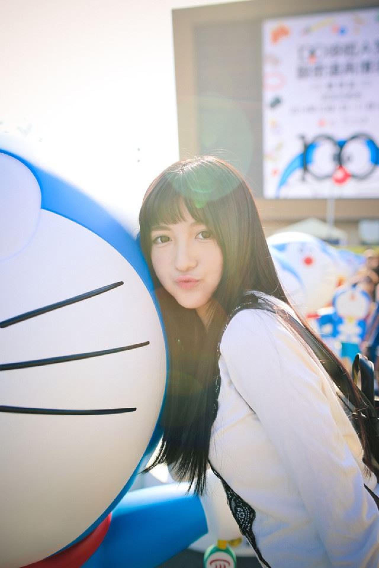 嗡嗡贴着哆啦A梦的脸嘟嘴卖萌