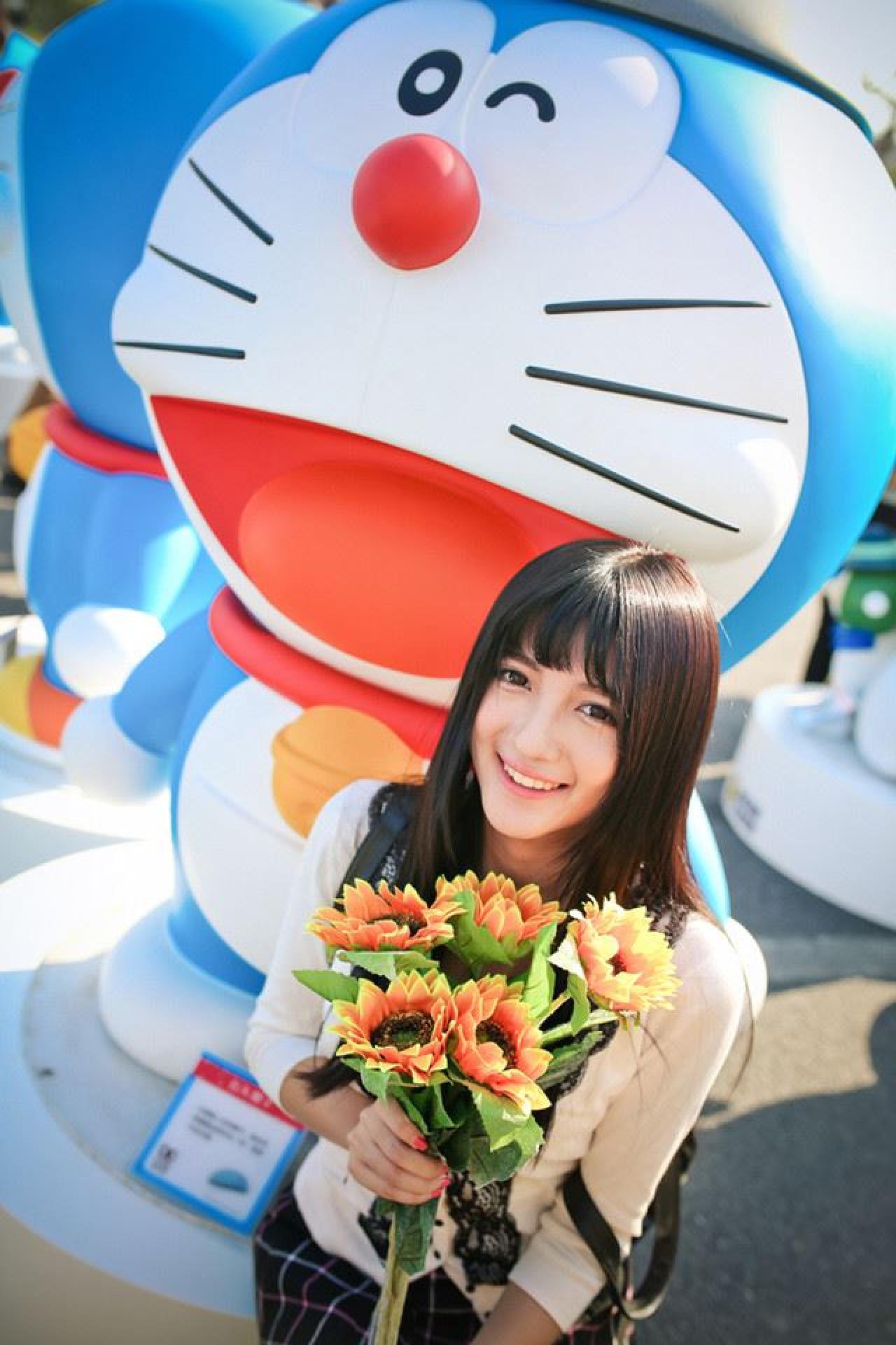 嗡嗡捧着鲜花坐在哆啦A梦的台子上