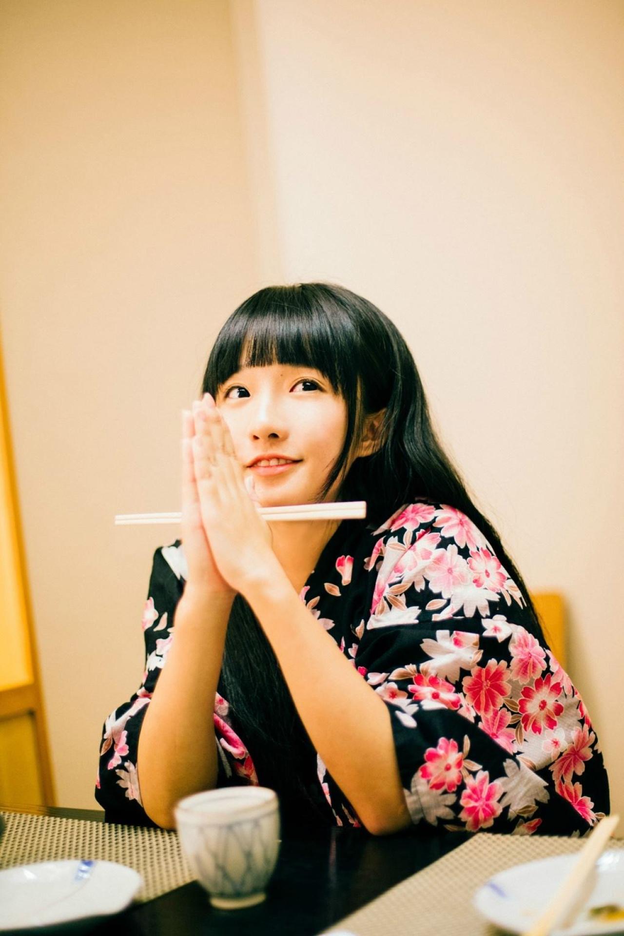 小陆离双手合十，夹着筷子坐在餐桌旁，好像祷告的样子