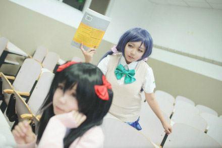 慕斯扮演东条希拿着厚厚的课本悄悄地站在正在发呆的阿琴扮演矢泽妮可身后