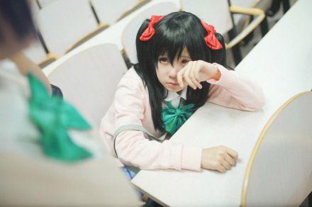 慕斯扮演东条希惊醒扒着桌子，揉揉眼睛，无辜地看着慕斯扮演东条希