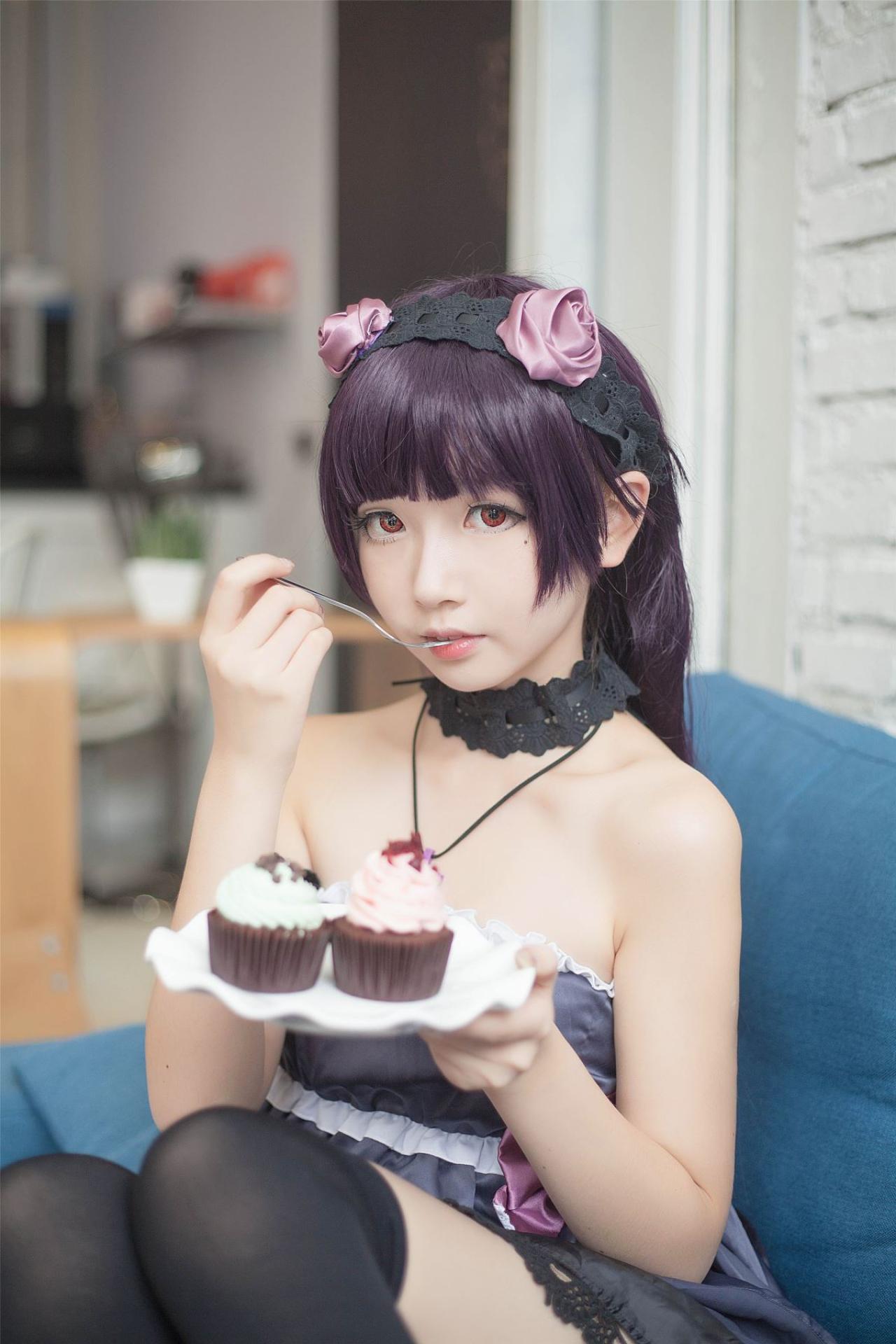 小圆脸雪雪扮演黑猫右手拿着叉子放进嘴里，左手端着放着点心的盘子