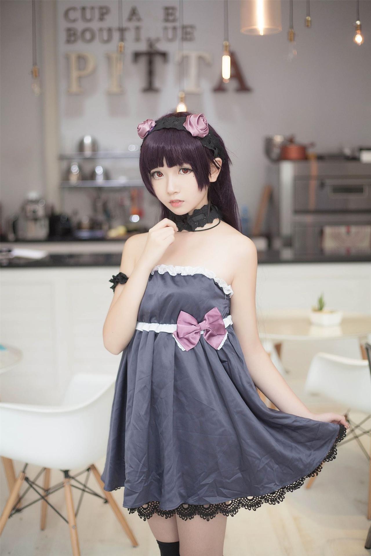 小圆脸雪雪扮演黑猫右手放在颈部，左手拎起裙角