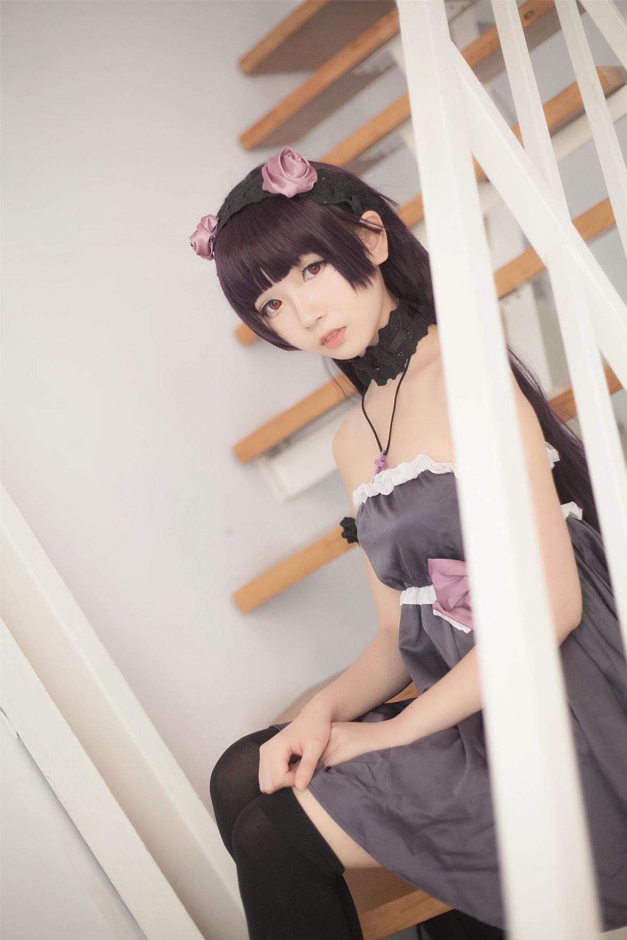 小圆脸雪雪扮演黑猫侧身坐在台阶上