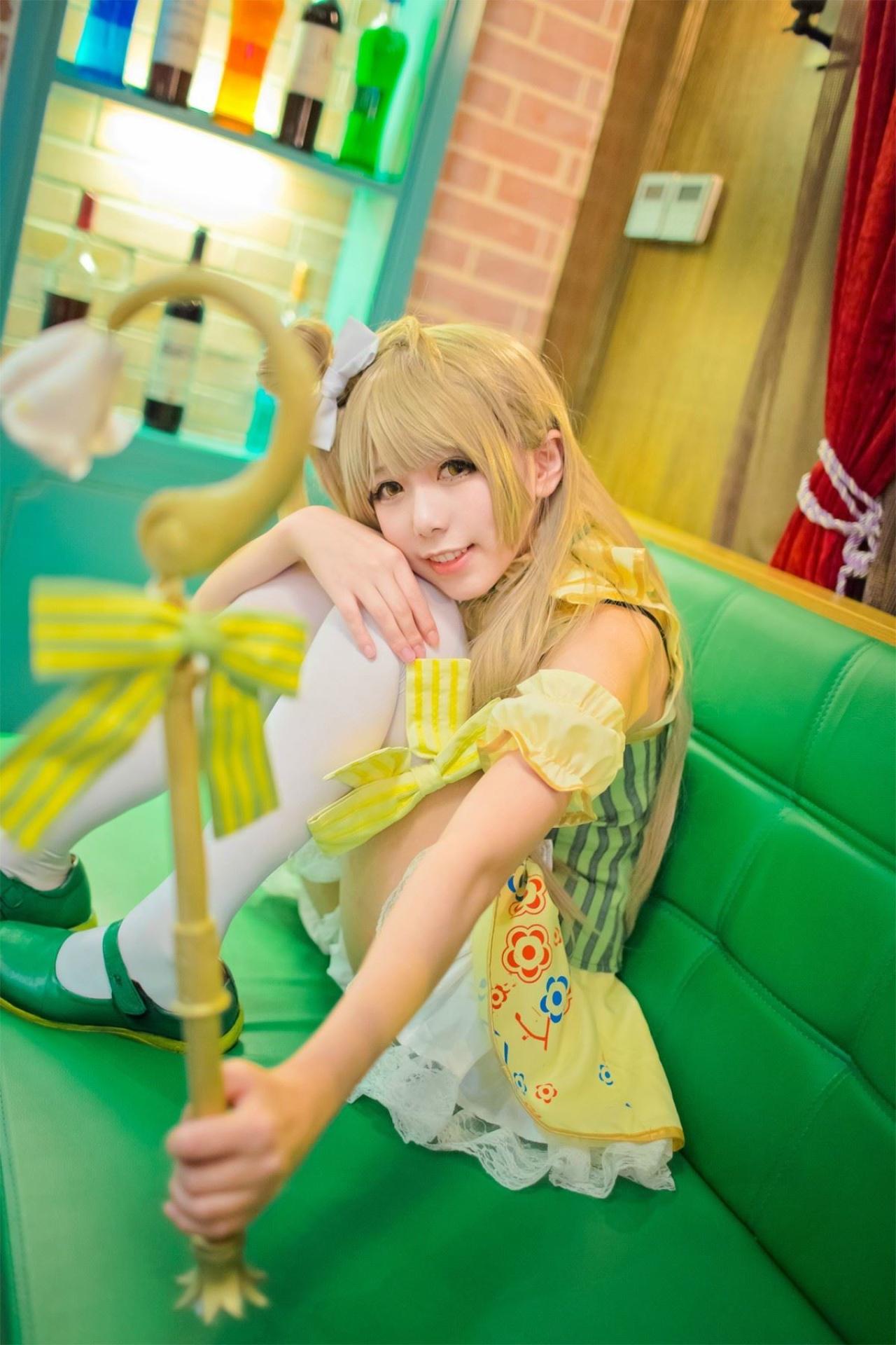 胡纸姐姐扮演南小鸟右手抱着膝盖，左手拿着手杖坐在椅子上