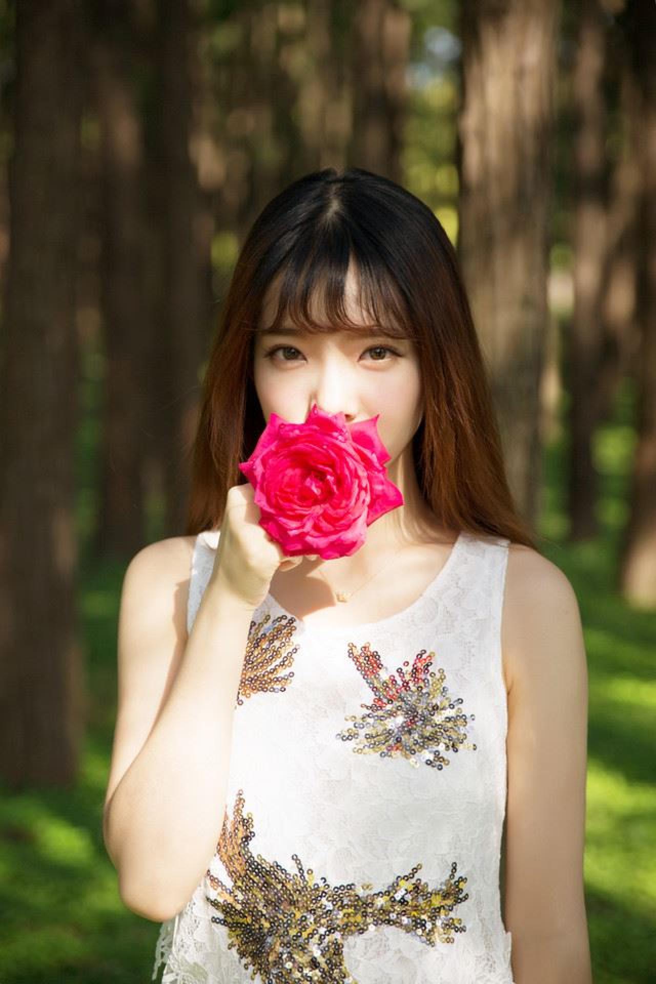 萌妹子拿着一多紫色花朵放在嘴边