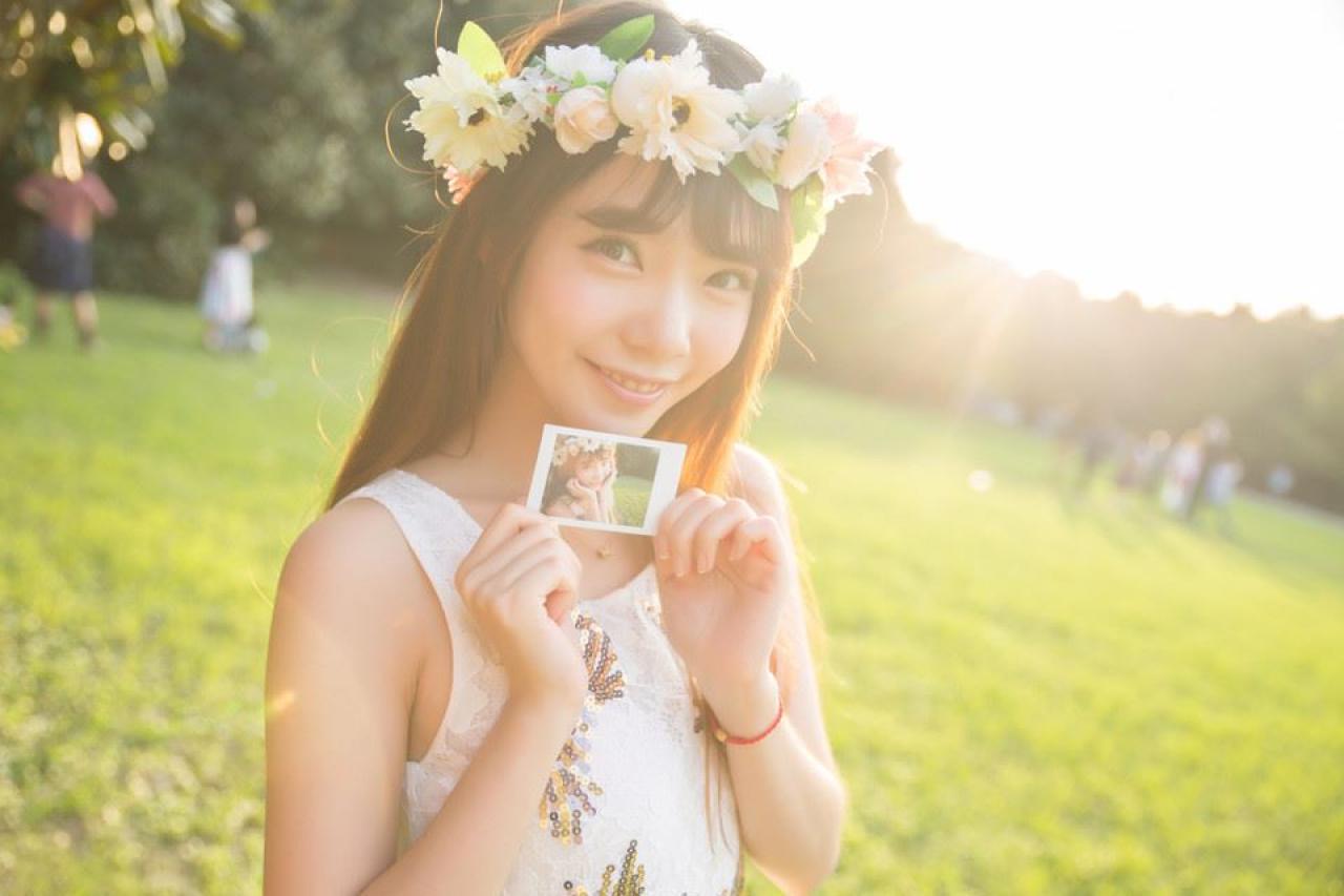 萌妹子双手捏着一张明信片，明信片上是自己的照片