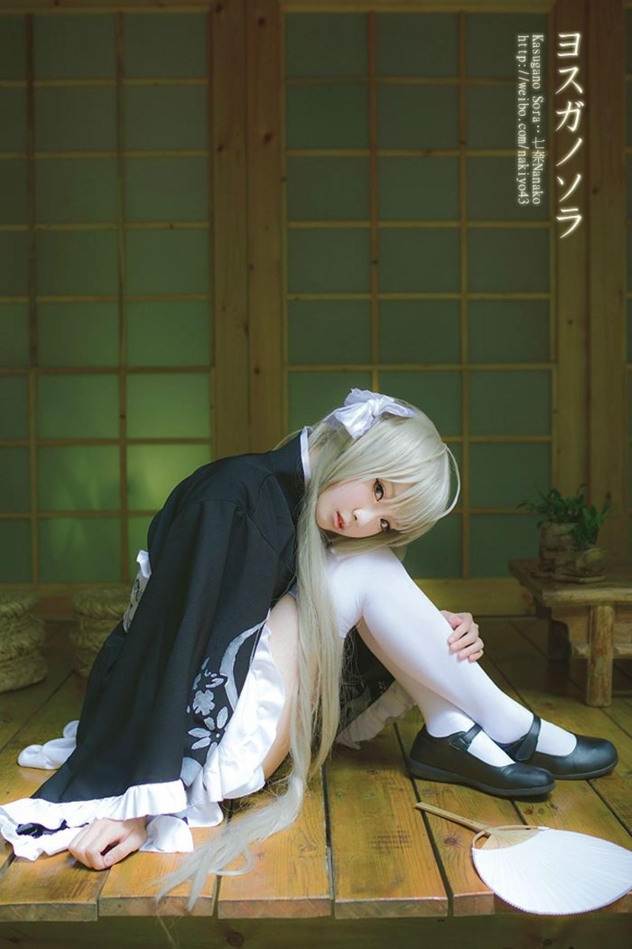 七奈扮演春日野穹抱着膝盖坐在门前