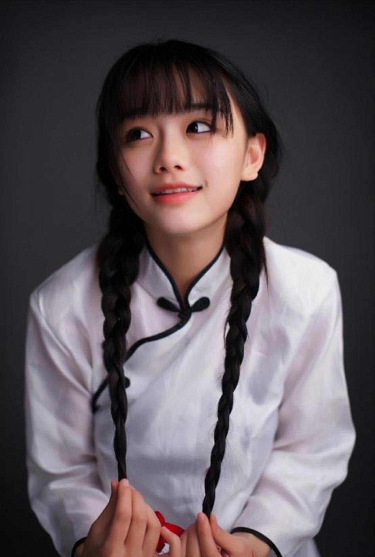 南笙姑娘双手拉着双马尾辫子尾部，眼睛斜视前方