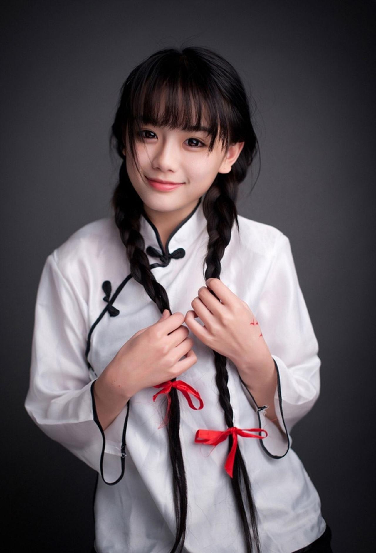 南笙姑娘双手轻抚双马尾辫全身照