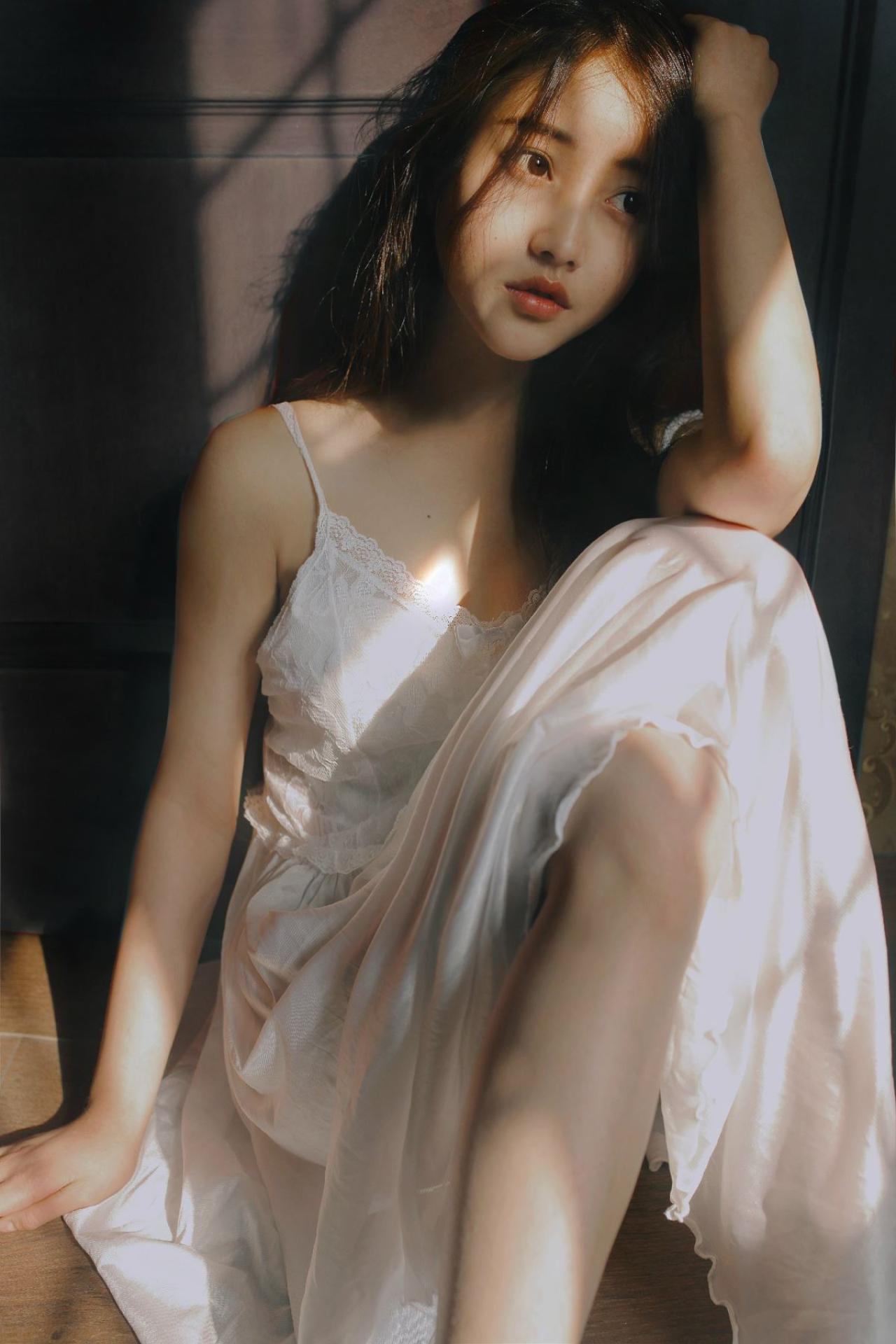 垚昕靠坐在窗旁，左手搭在膝盖上轻抚头发，看向窗外