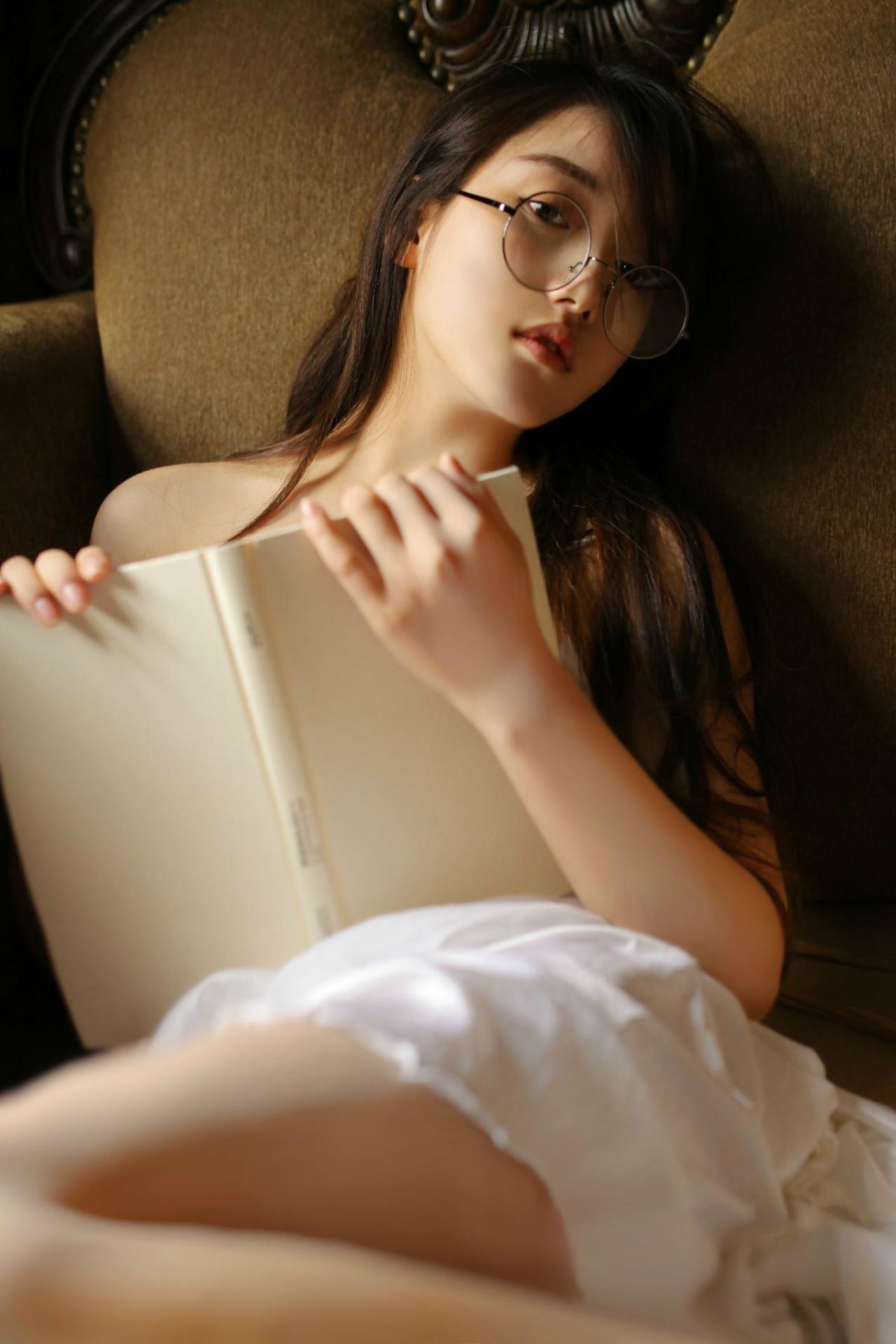 垚昕抱着白色书本斜躺在沙发里