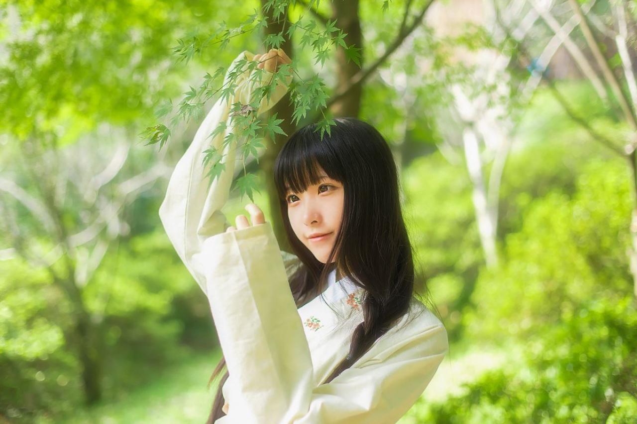 半藏森林穿着绿色上衫双手捏着树叶