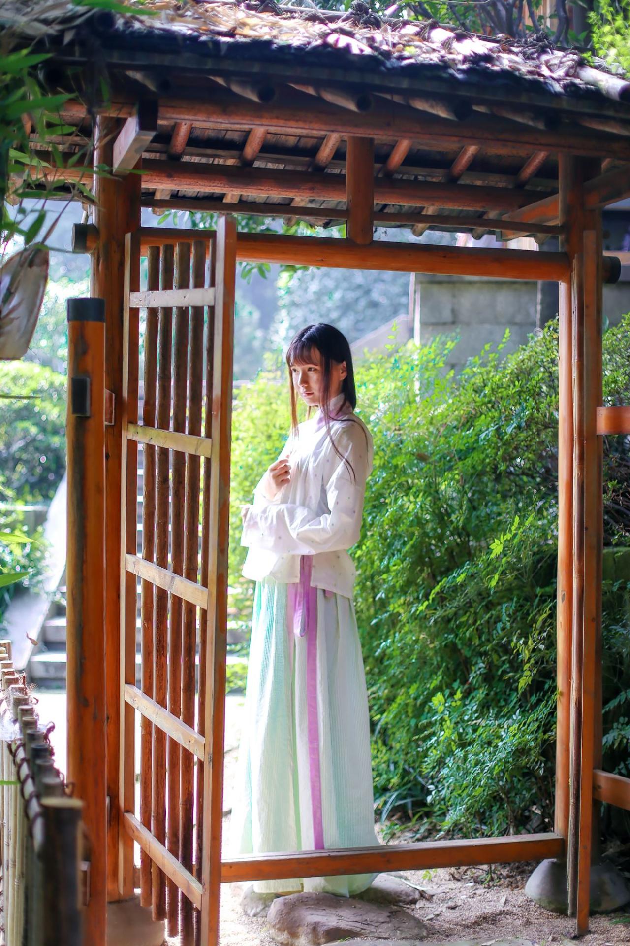 瞬瞬穿着白色上衫在门前侧面照