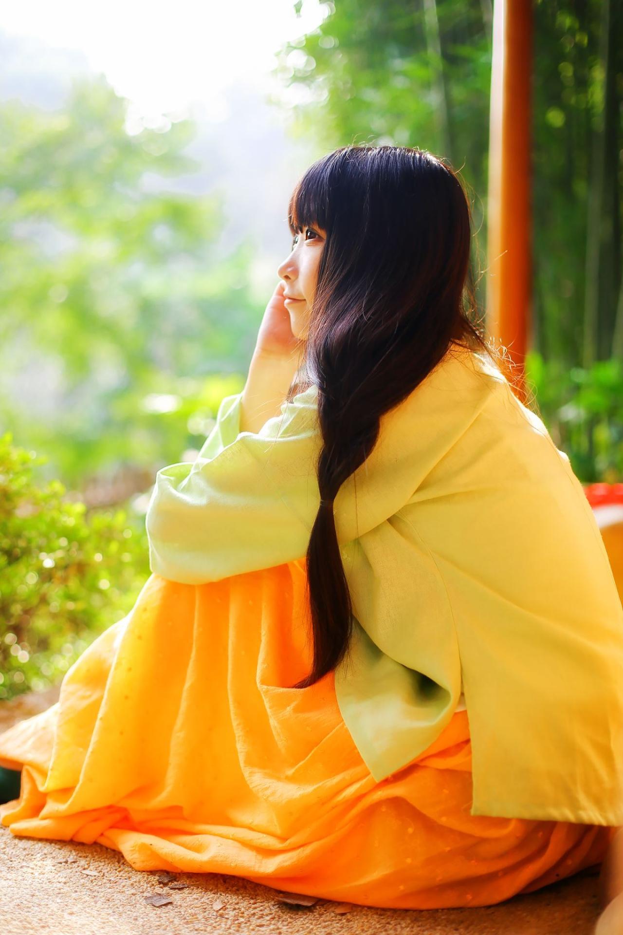 半藏森林穿着绿色上衫，黄色长裙抱着膝盖坐着