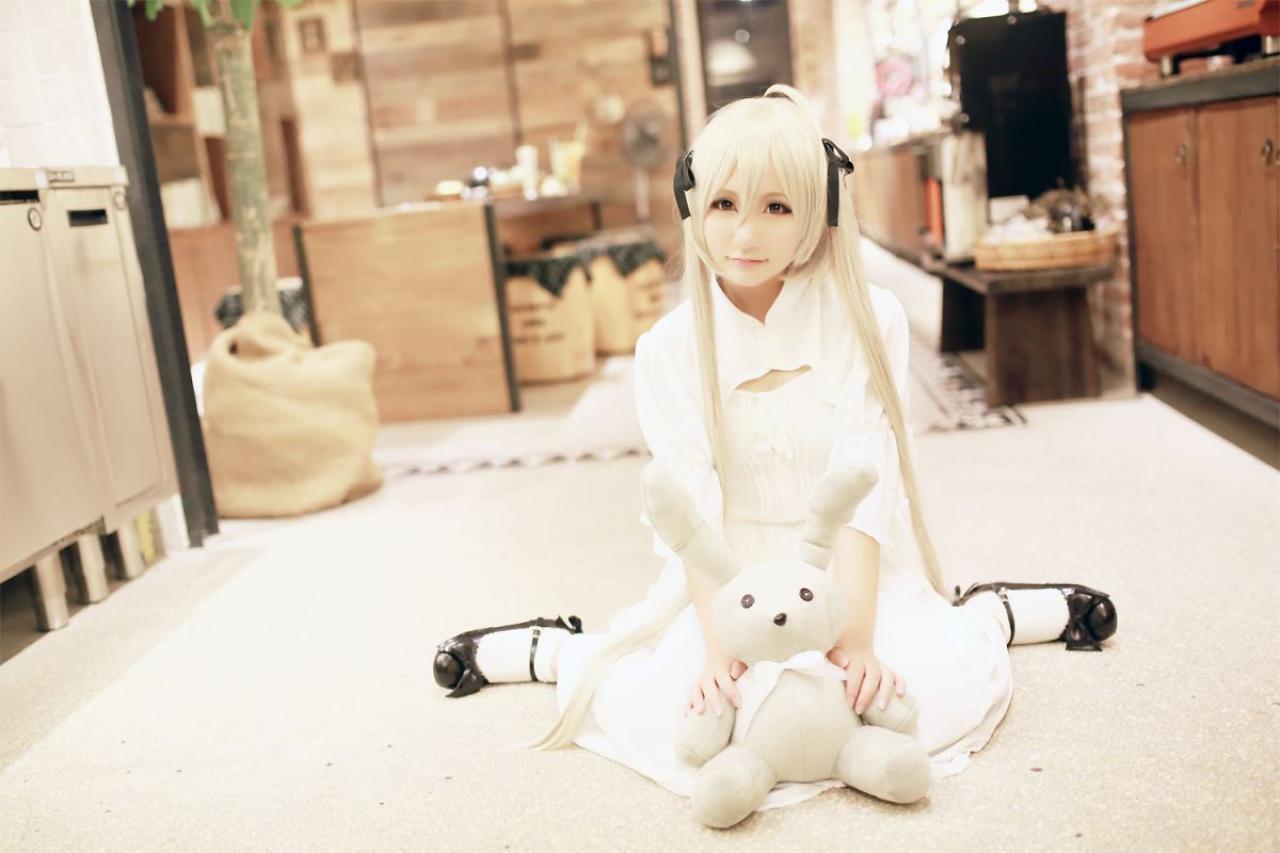 熊叽扮演春日野穹跪坐在地毯上，双手搭在兔子玩偶上正面照