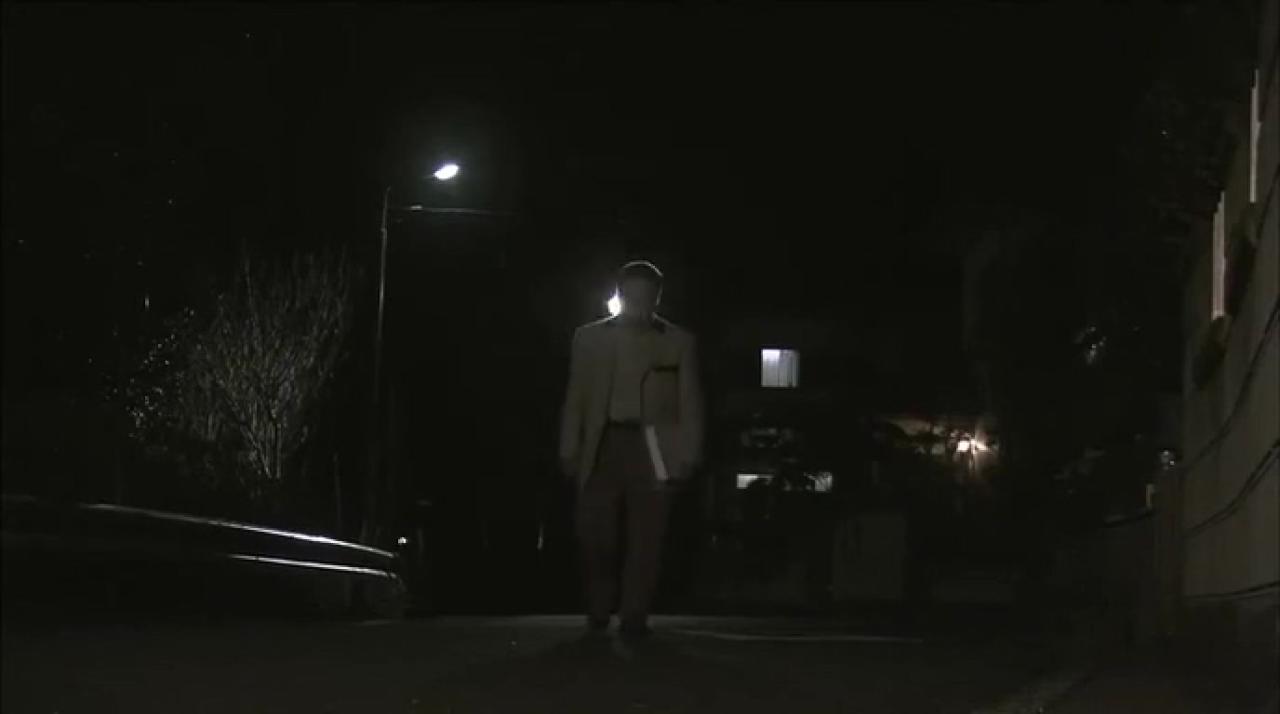 大叔独自一人走在昏暗的灯光下