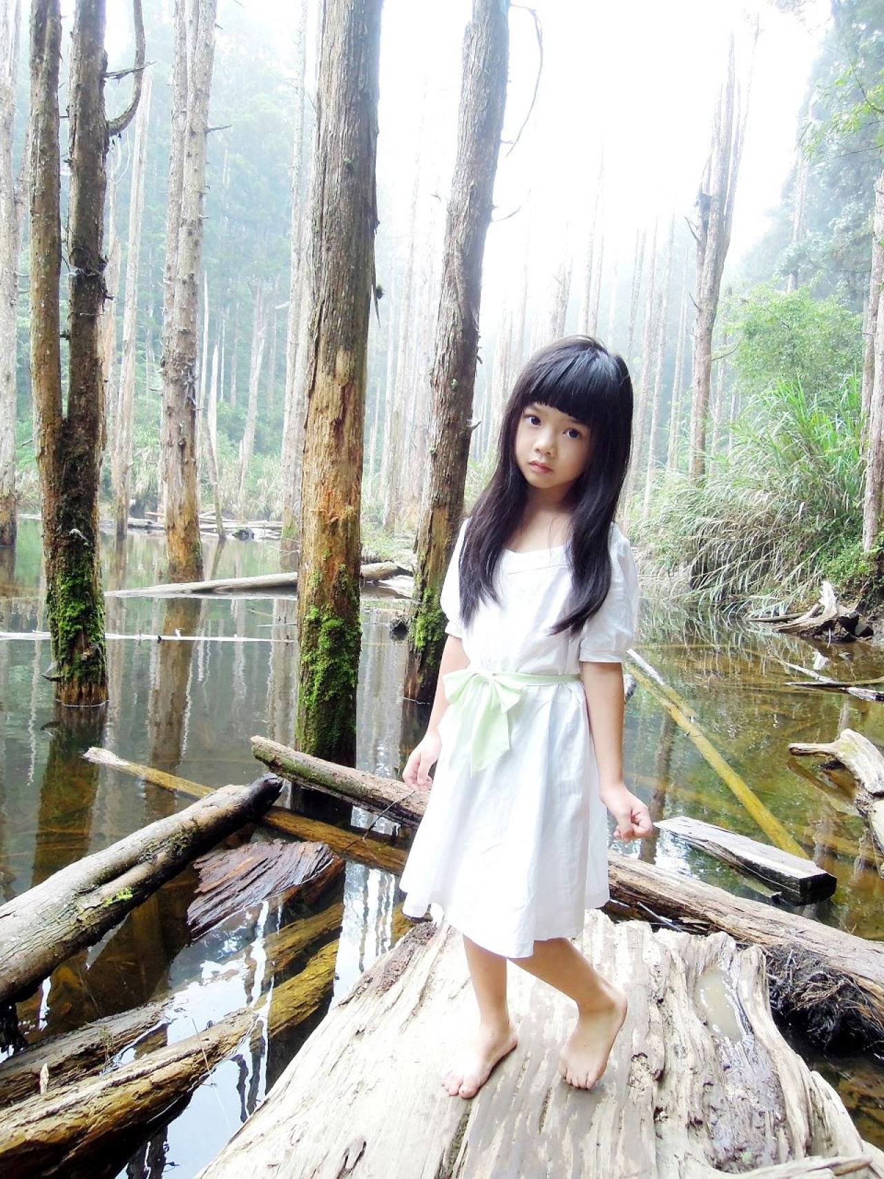 Yui光着脚丫站在水中的树干，歪着脑袋的模样