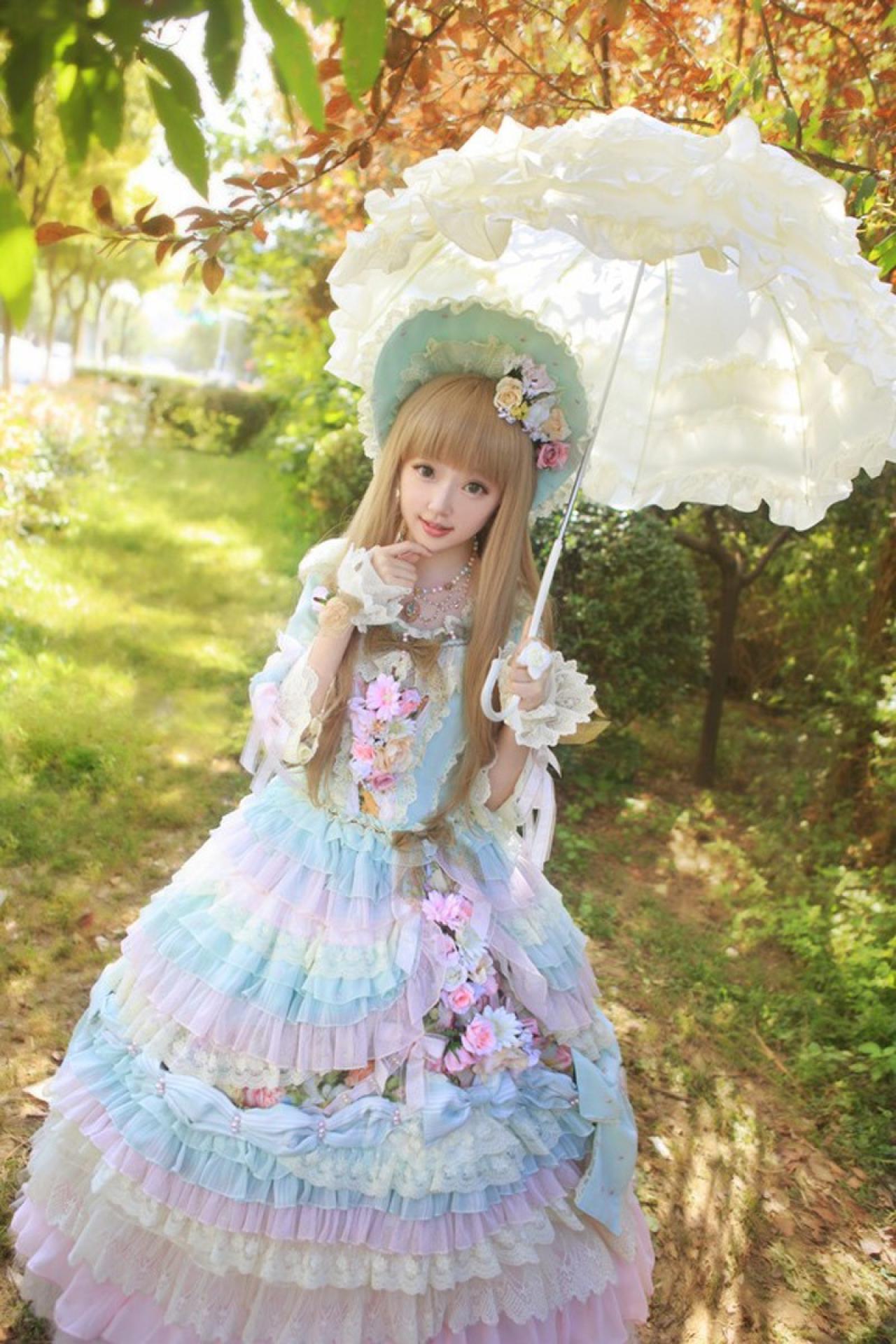 小芽左手撑伞，右手轻捏下巴