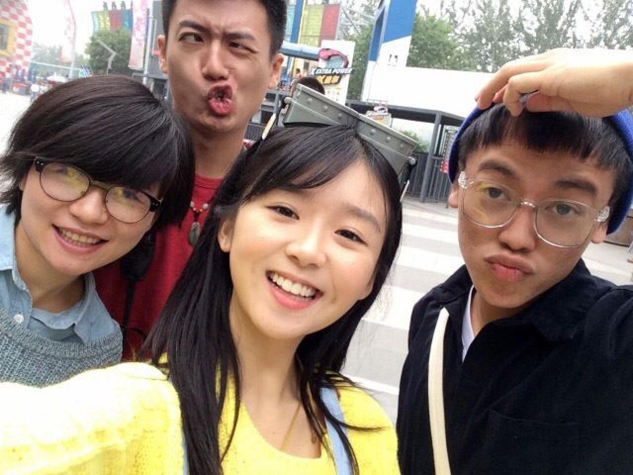 大家都是普通表情，红衣男孩还在作鬼脸，也是蛮拼的图片