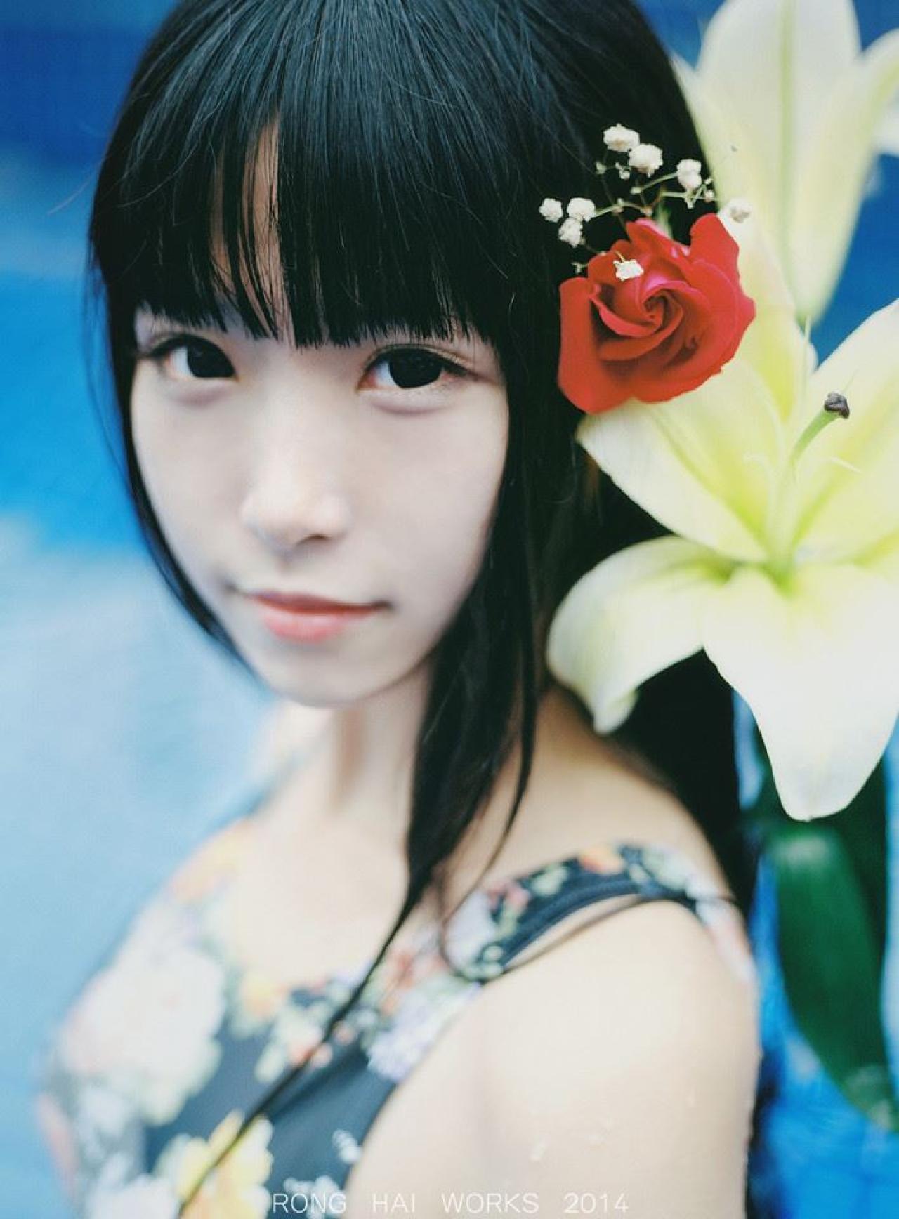 半藏森林头戴红花背靠着鲜花看向镜头