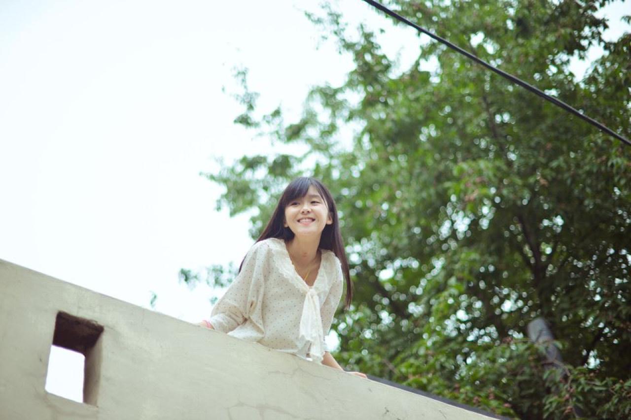 宋伊人穿着白衣微笑扒在桥上