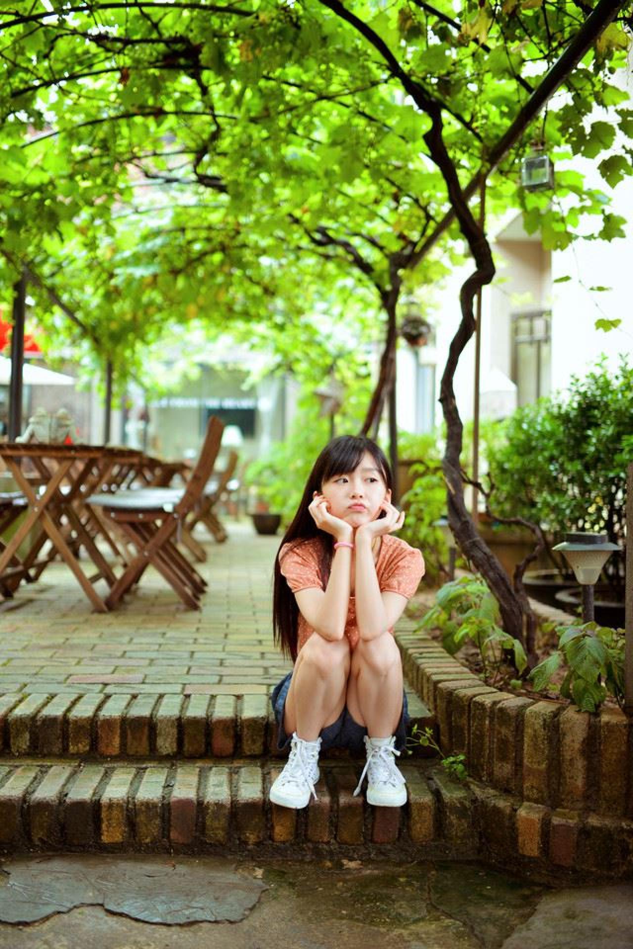 宋伊人坐在台阶上双手捧着脸嘟嘴卖萌