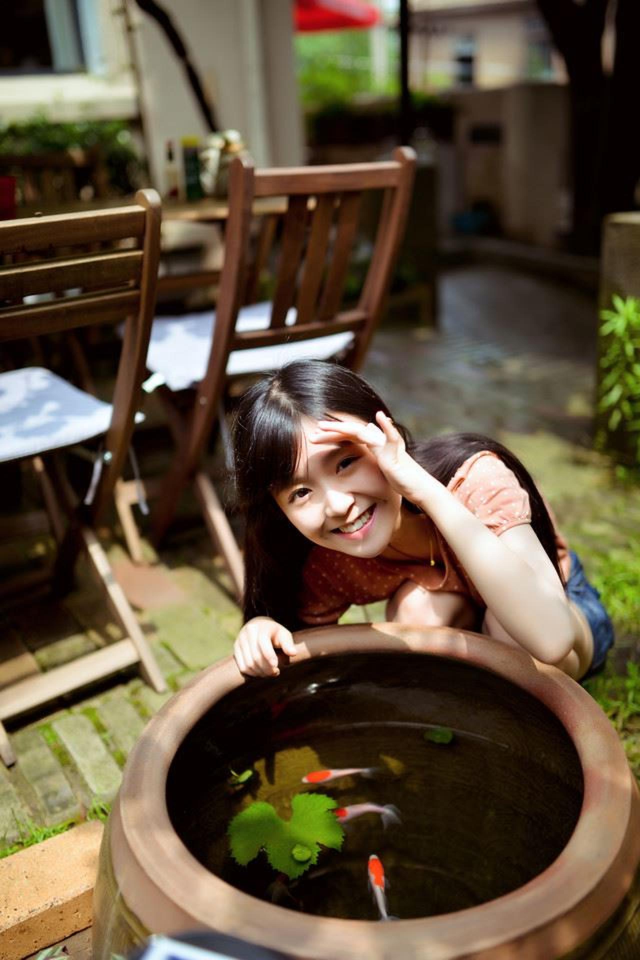 宋伊人扒在鱼缸旁，左手遮着阳光