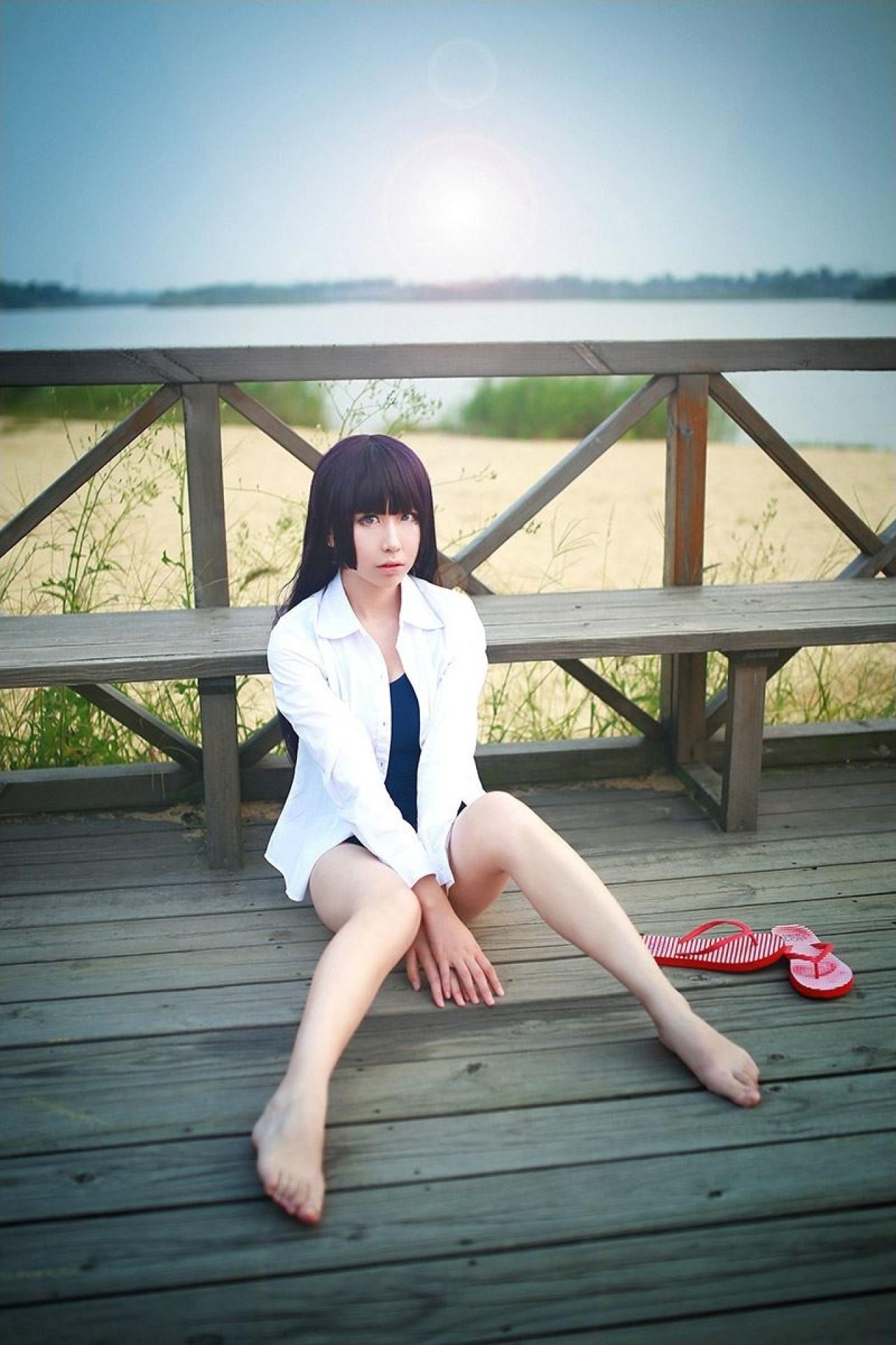 月歌扮演五更琉璃脱鞋坐在木板，靠在长椅上（另一角度，背景可以看到大海沙滩）