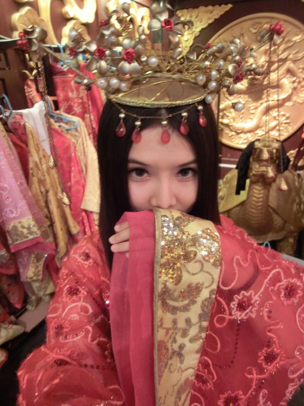 奕青含拂袖遮嘴红色古装照