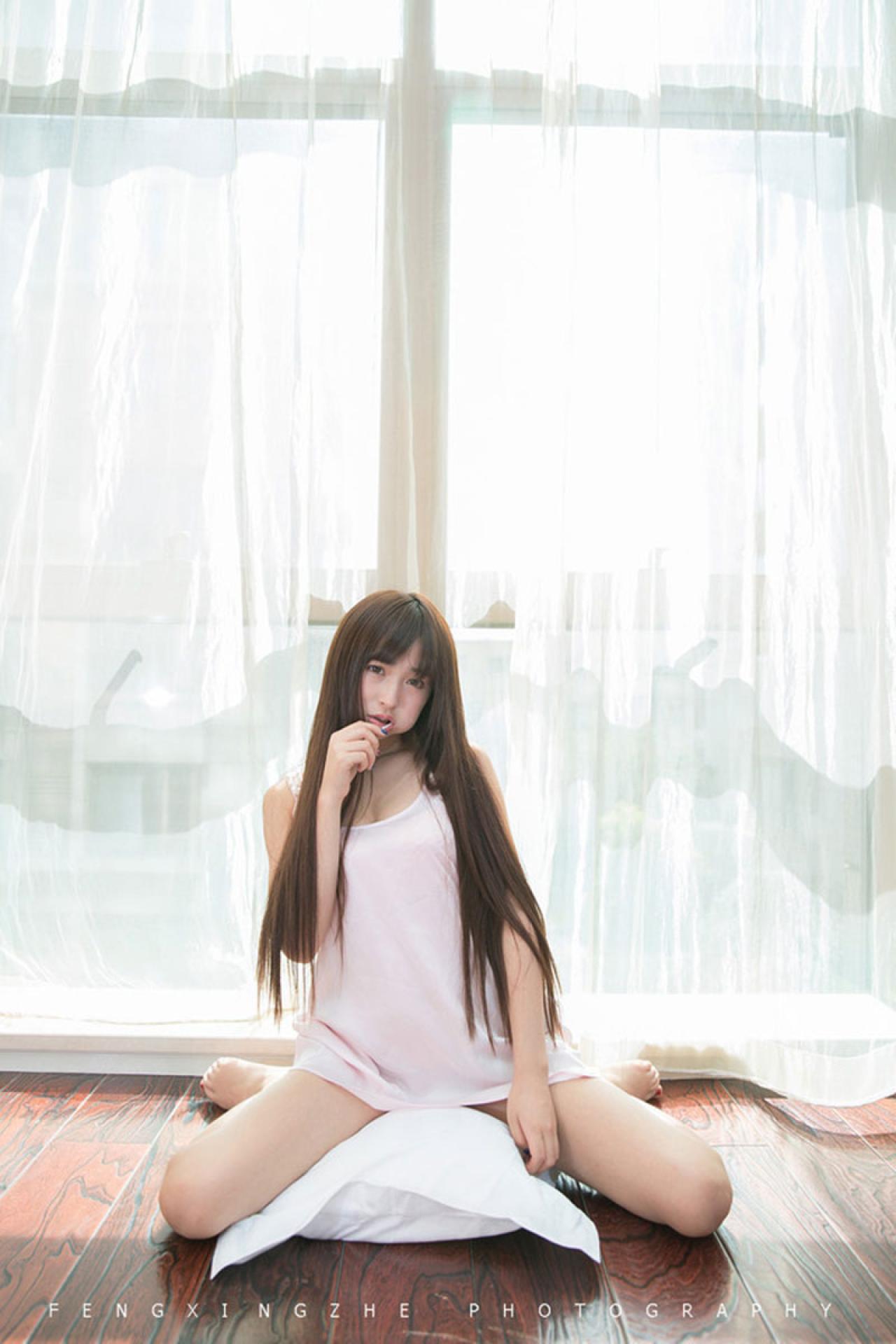 长直发的坐在枕头上，刷牙的动作，背景是白色落地窗帘