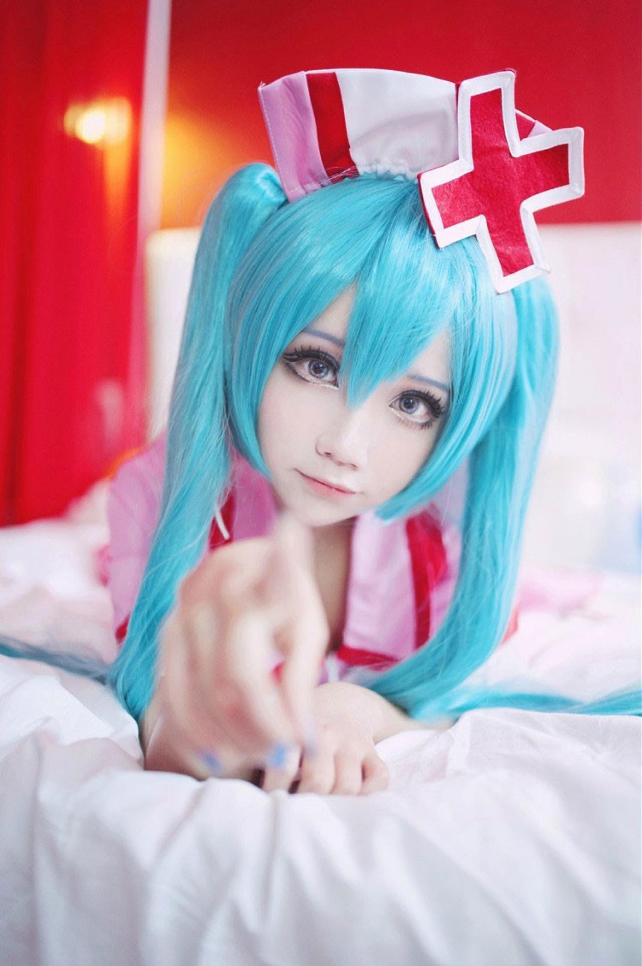 诡殊扮演初音未来趴在床上伸出右手食指