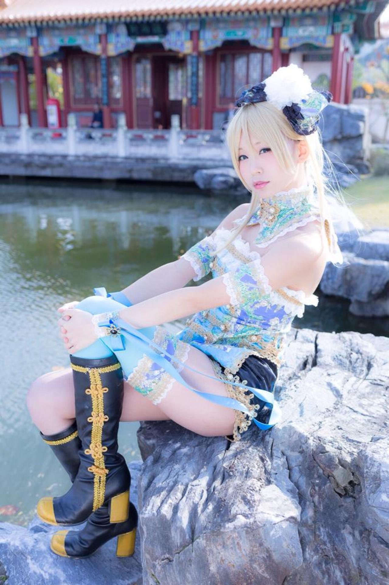 五木あきら扮演绚濑绘里坐在湖水旁的石头上，双手抱着膝盖