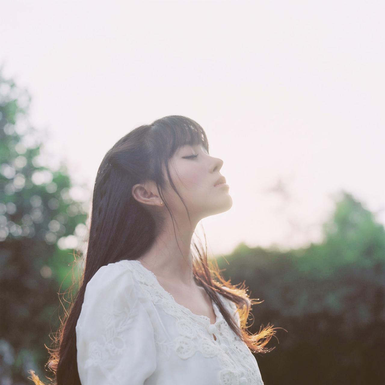 萌少女闭着眼睛，在林间抬头沐浴阳光