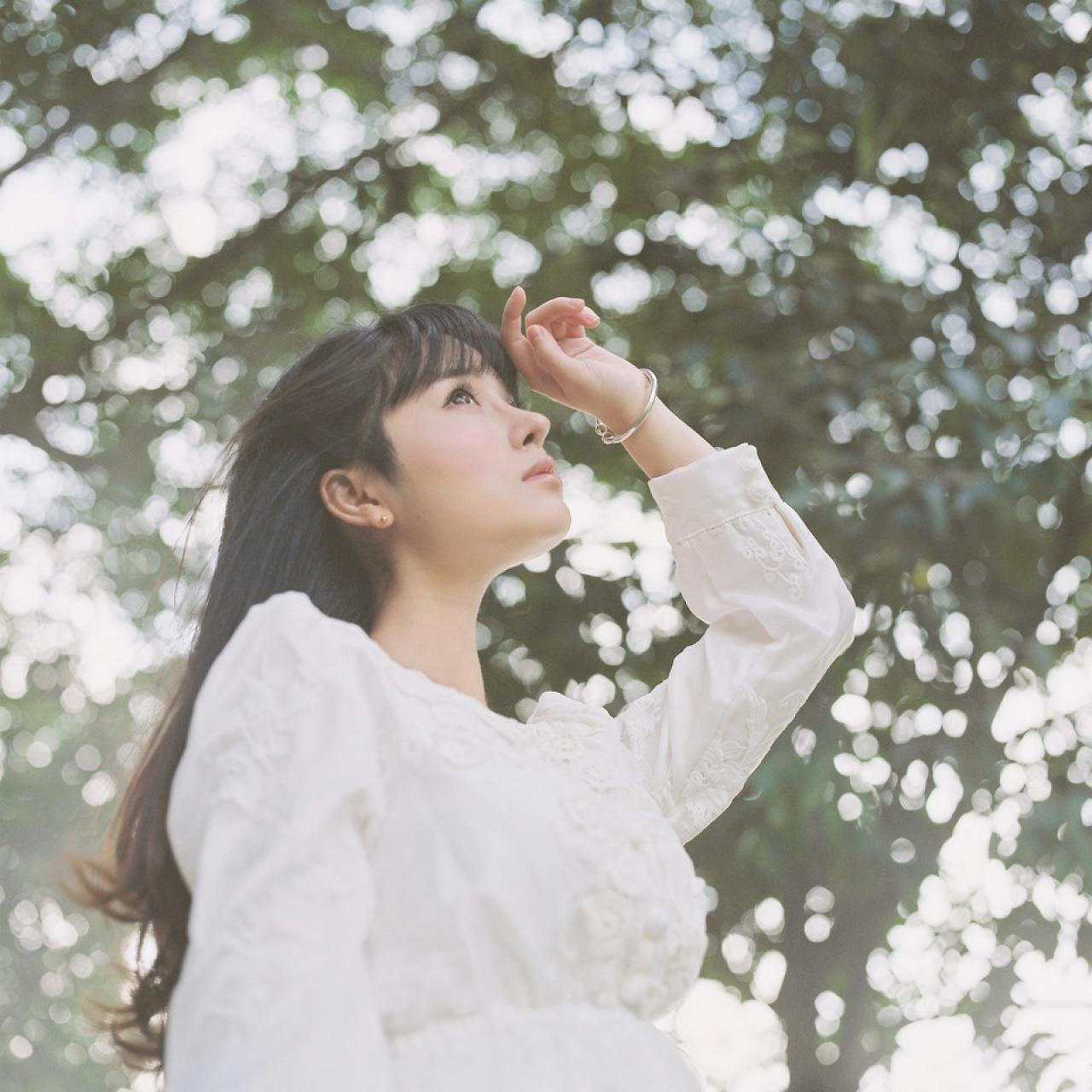 萌少女左手带着银色手镯，轻抚刘海儿，抬头仰望天空