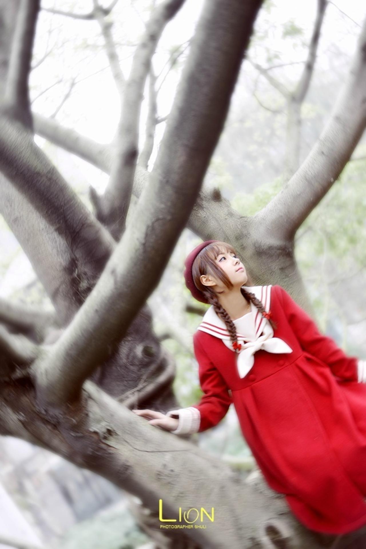 萌妹子右手扶着光秃但坚毅的树干