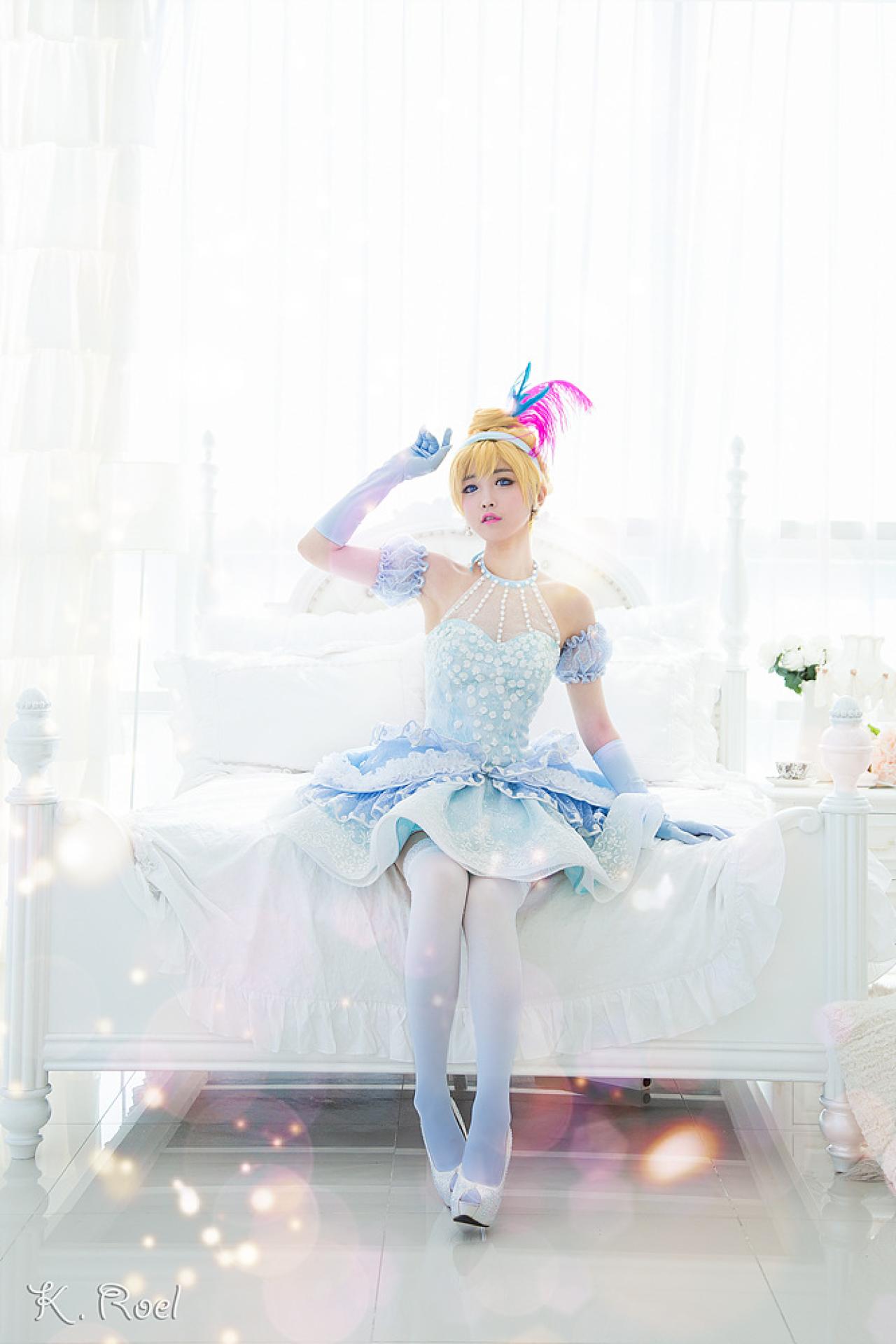 兔娘tomia扮演灰姑娘坐在床尾，抬起右手