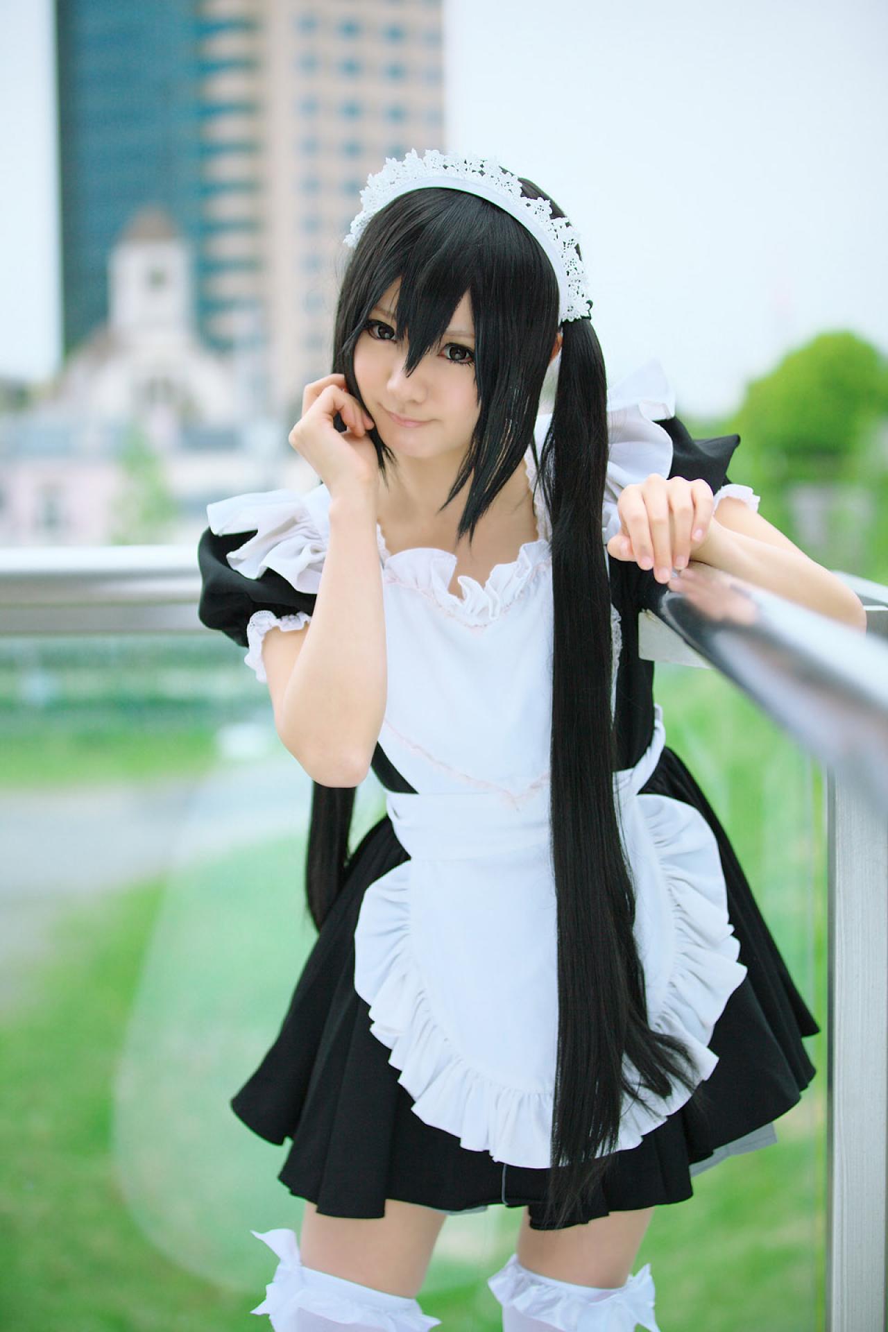 Maika扮演中野梓左臂放在栏杆上，右手轻抚刘海儿