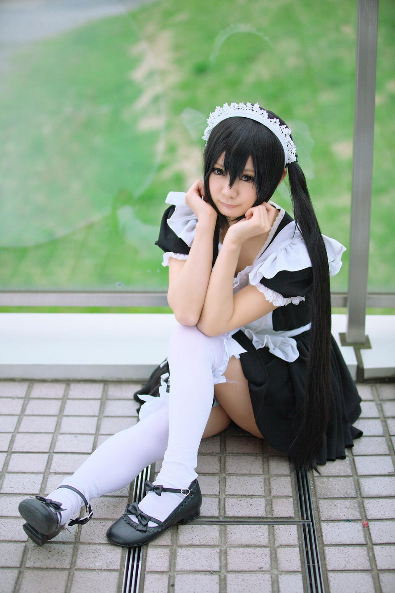 Maika扮演中野梓坐在地板上，双臂靠在一起