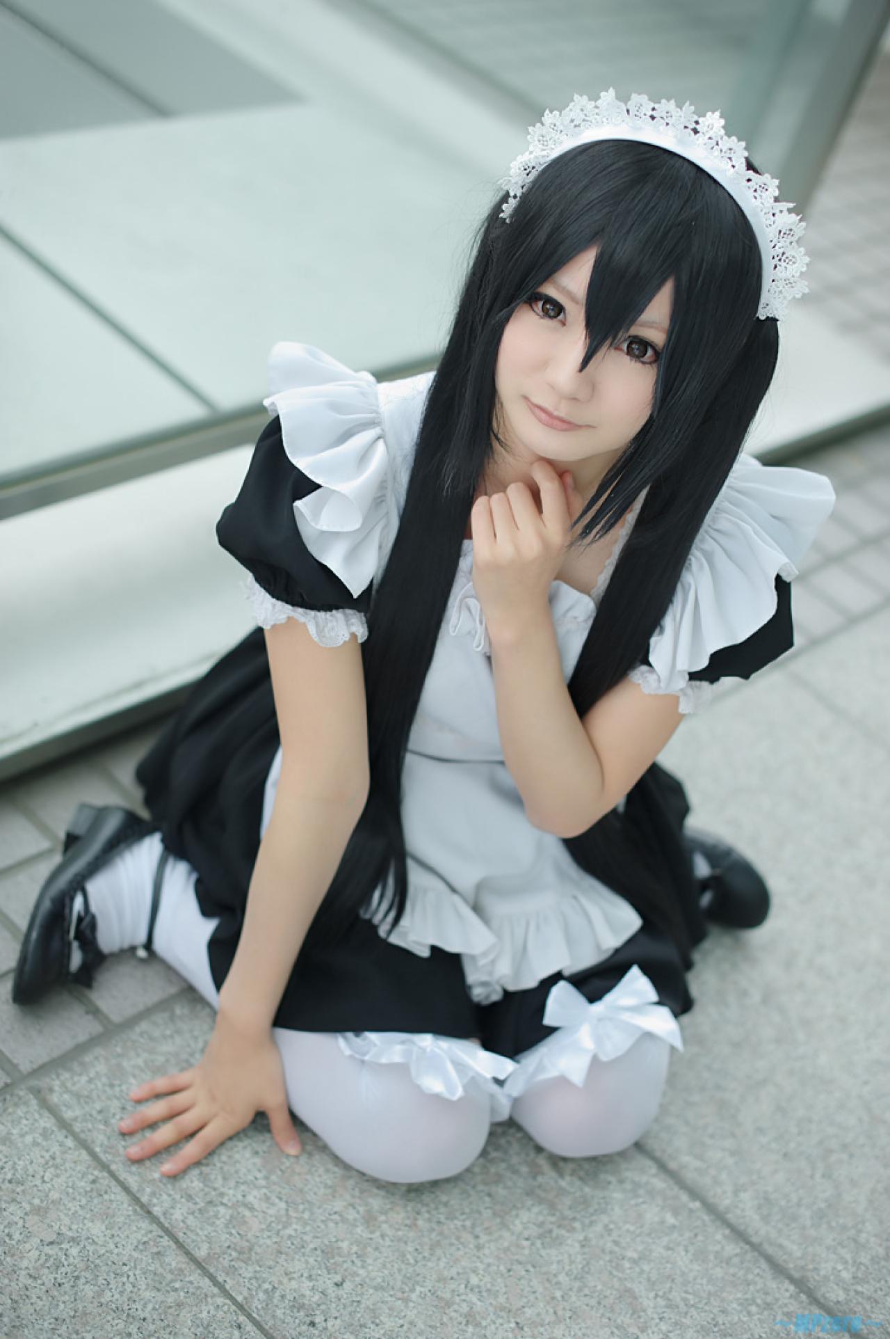 Maika扮演中野梓跪坐在地上，左手撑地，右手放在下巴下面