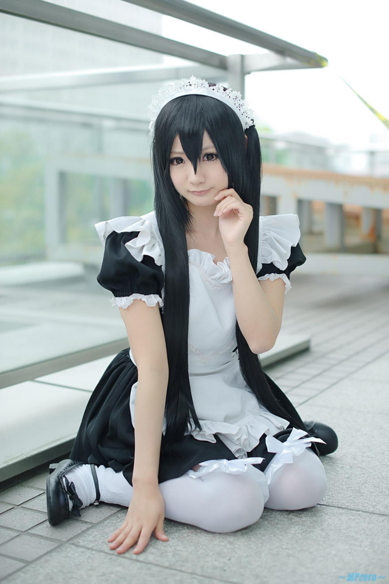 Maika扮演中野梓跪坐在地上，右手撑地，左手贴着脸颊