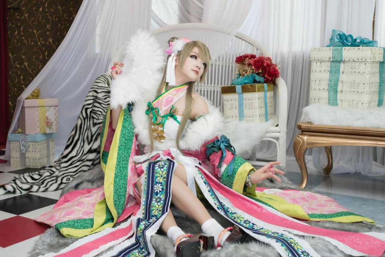 Miyuko扮演南小鸟右手持扇，顺着左手指的方向看去