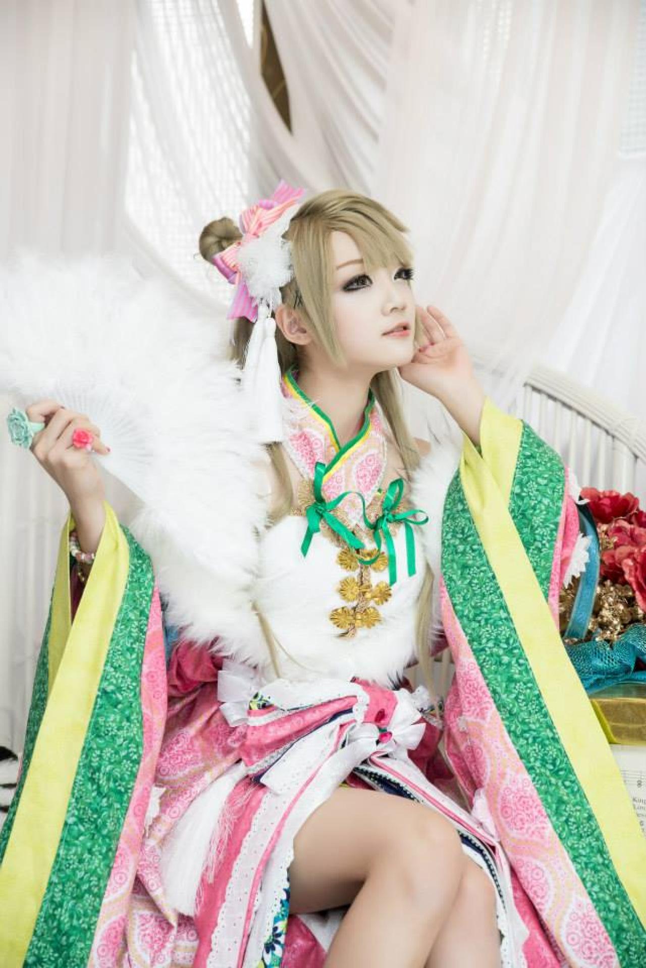 Miyuko扮演南小鸟右手持扇，左手贴在脸颊，侧耳倾听的神态