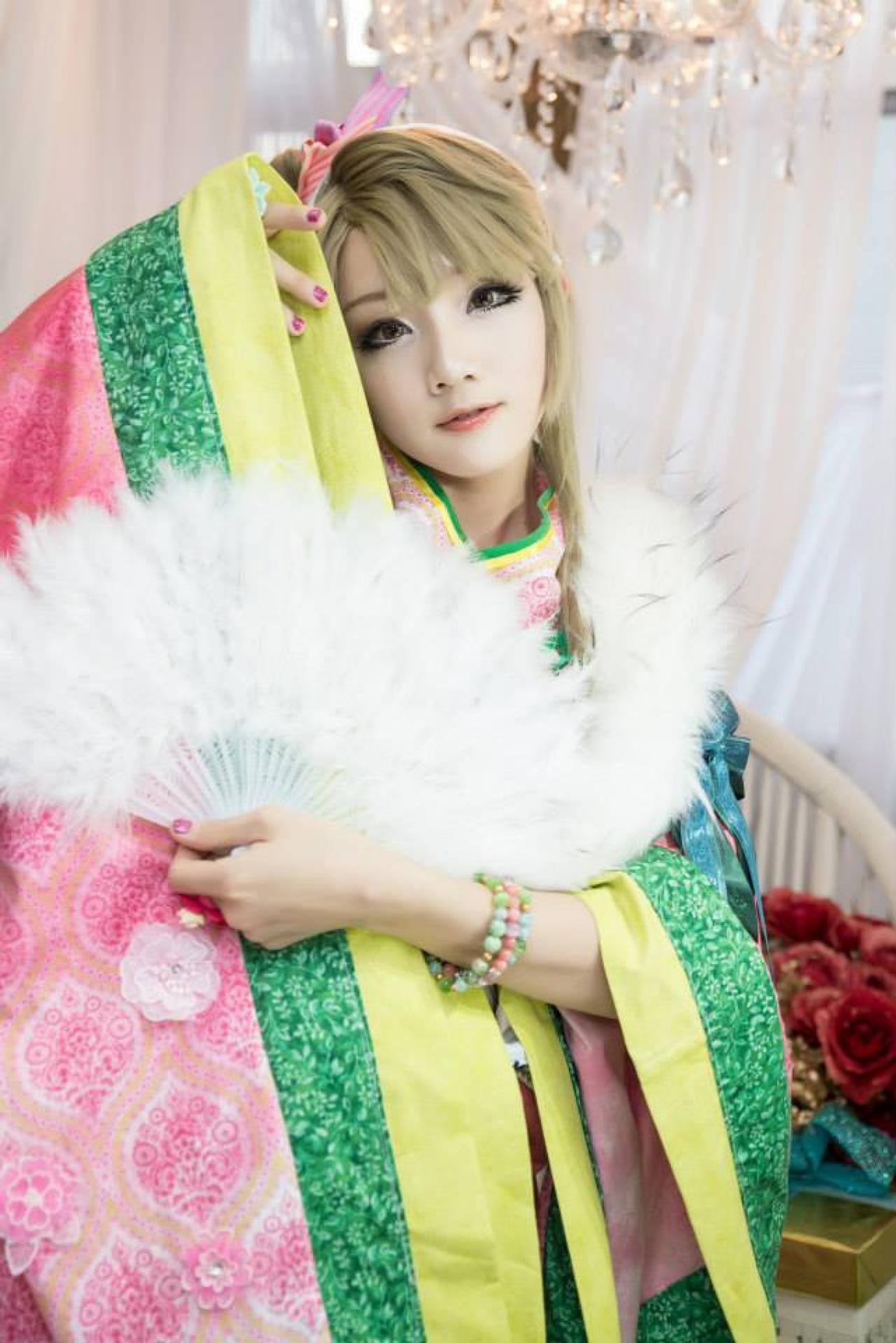 Miyuko扮演南小鸟右手抬起袖摆至额头处，左手撑伞遮挡