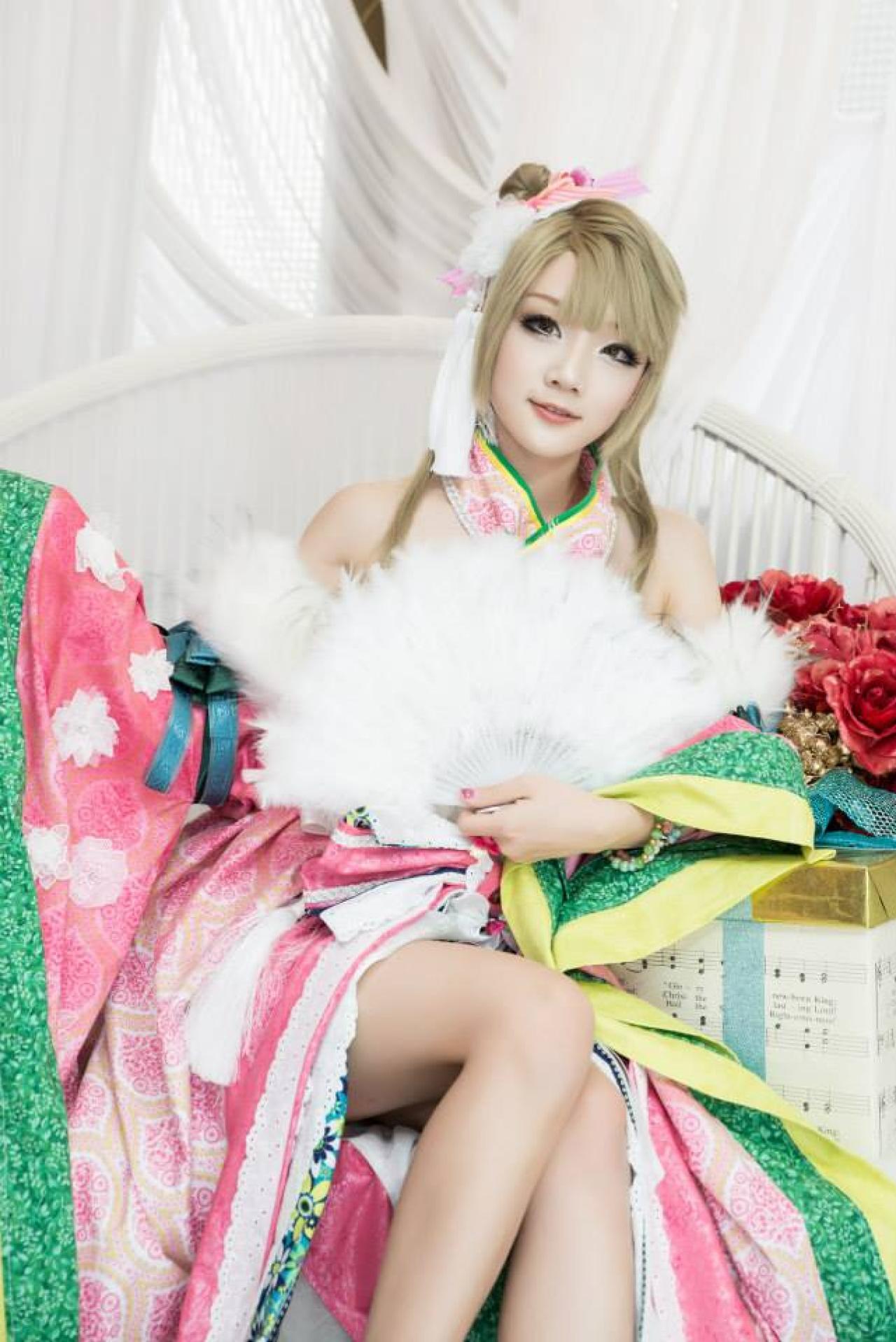 Miyuko扮演南小鸟半披外套，左手撑扇坐在椅子上