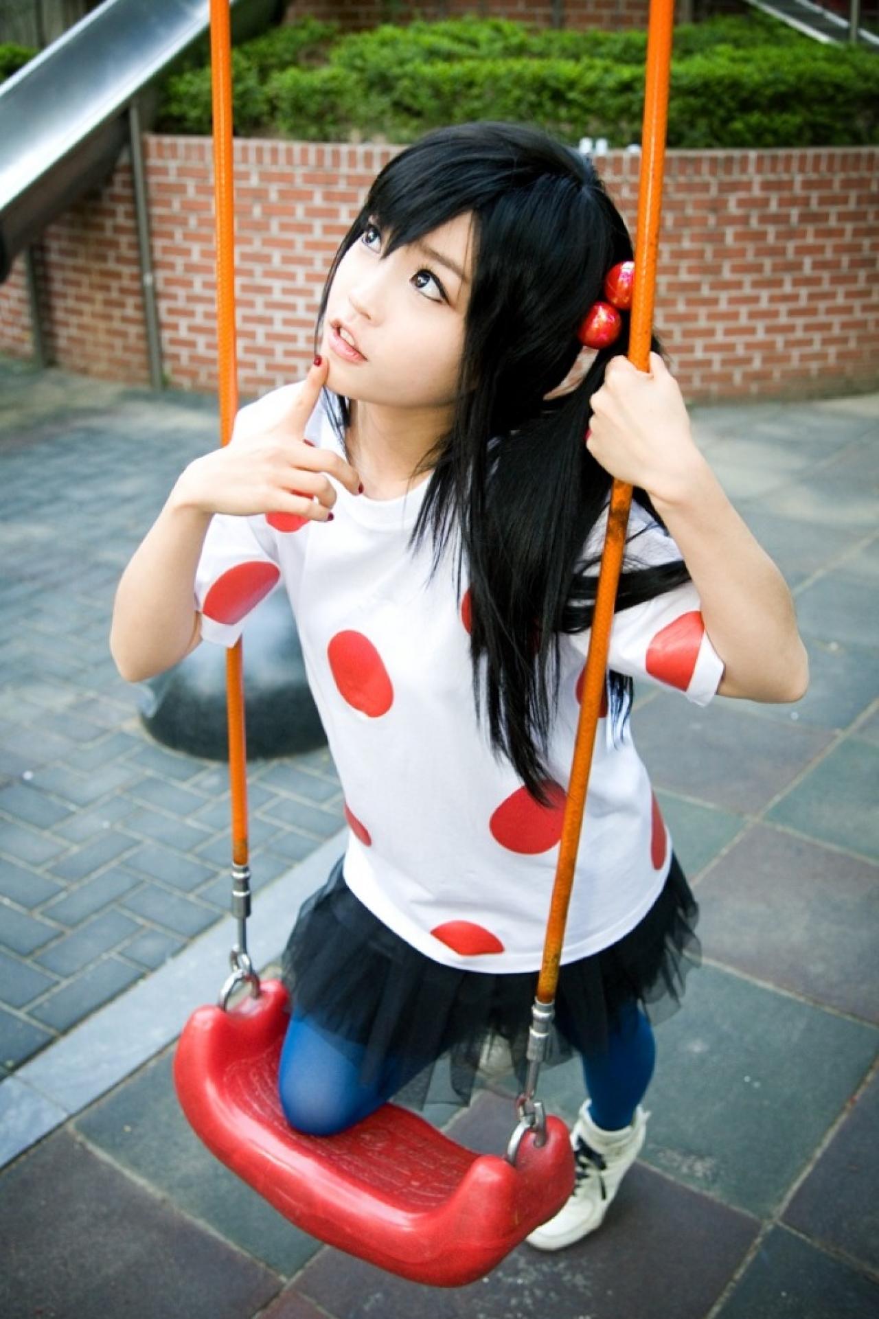 兔娘tomia扮演中野梓扒在秋千上，右手食指抵在下巴上，抬头仰望